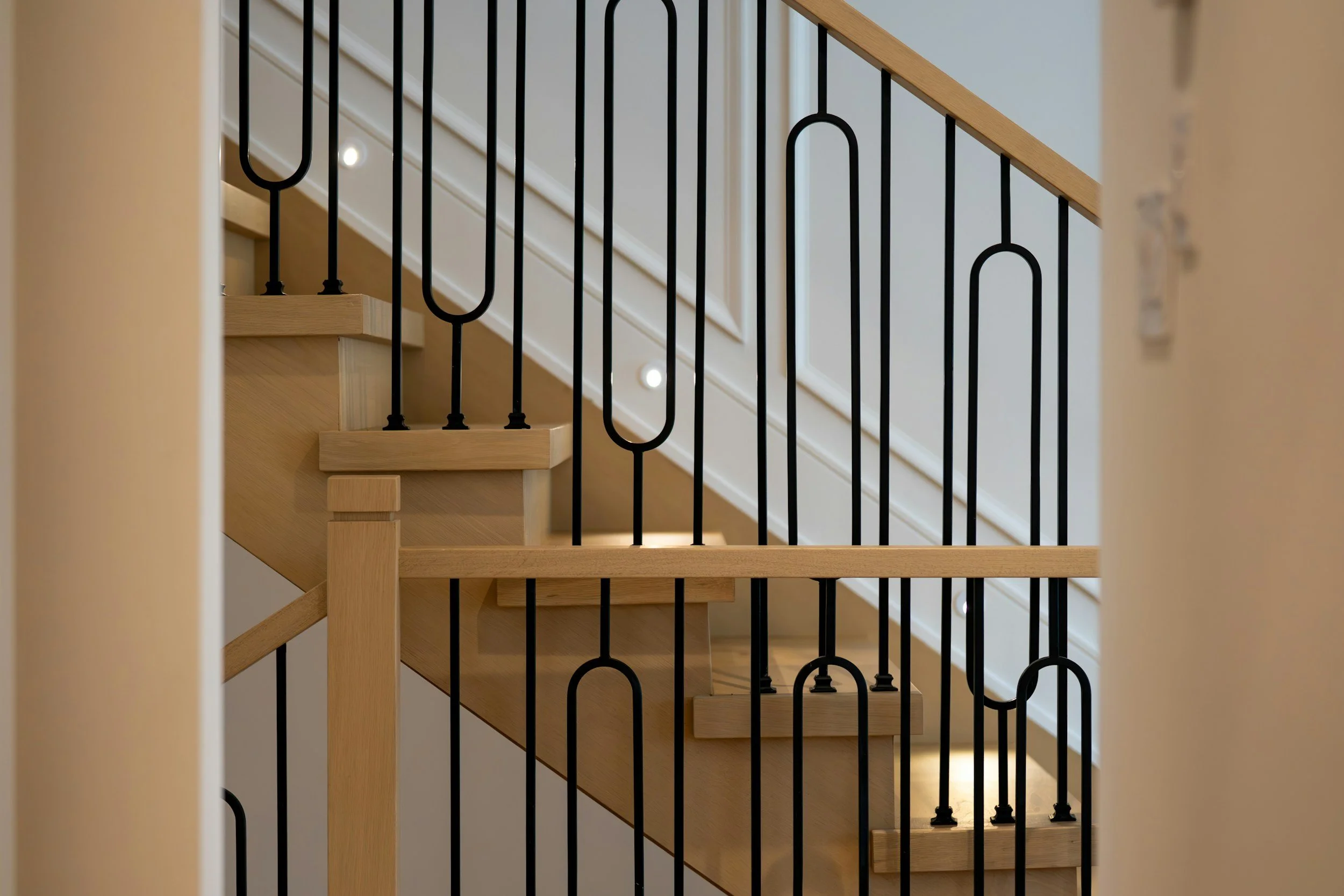 Houten trap met modern zwart hekwerk in een woning
