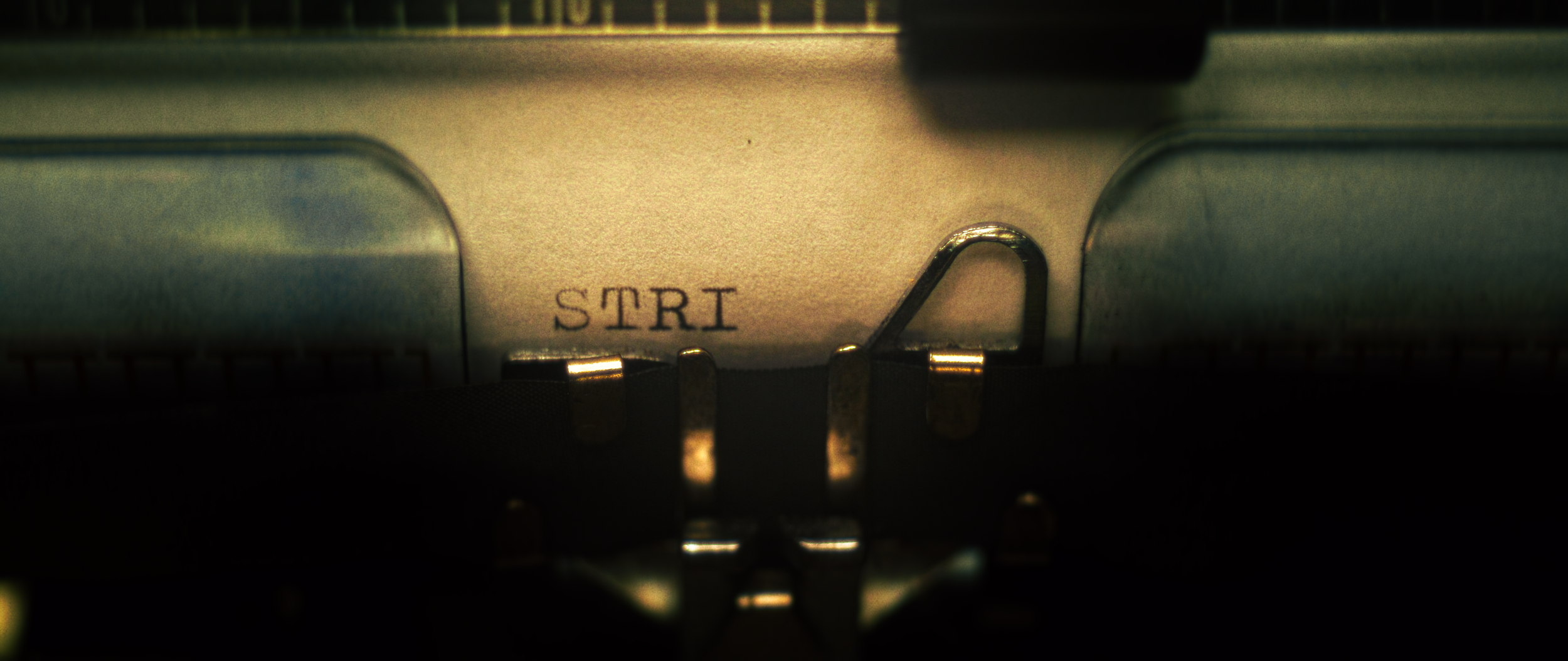Close-up of a vintage typewriter's mechanical shutter with the word 'START' written beside the start lever