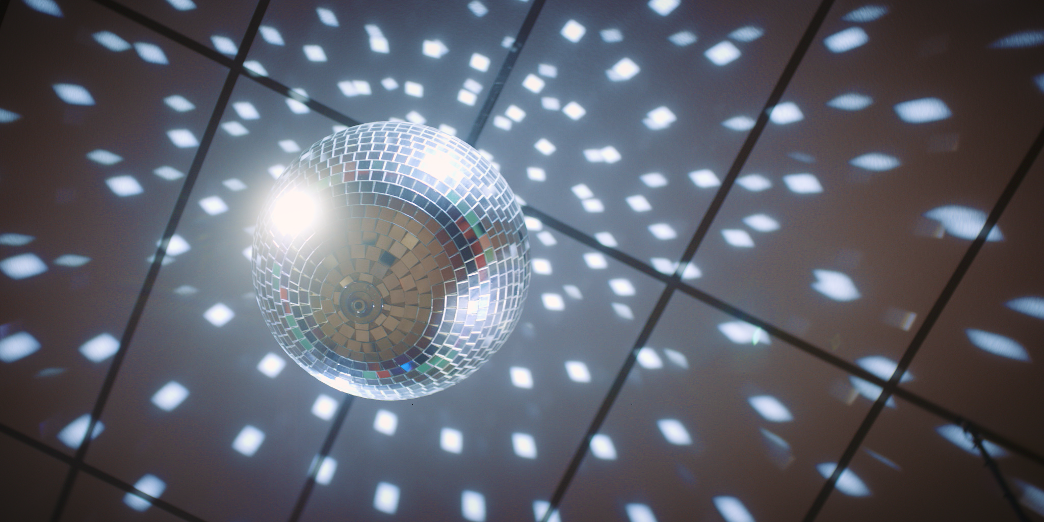 A disco ball reflecting light patterns on a ceiling.
