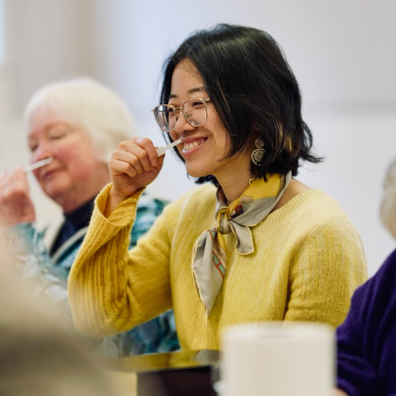Women smiling and using perfume scent strips at a perfume and diffuser making workshop by Clean Burn Candle and Scentsetiva