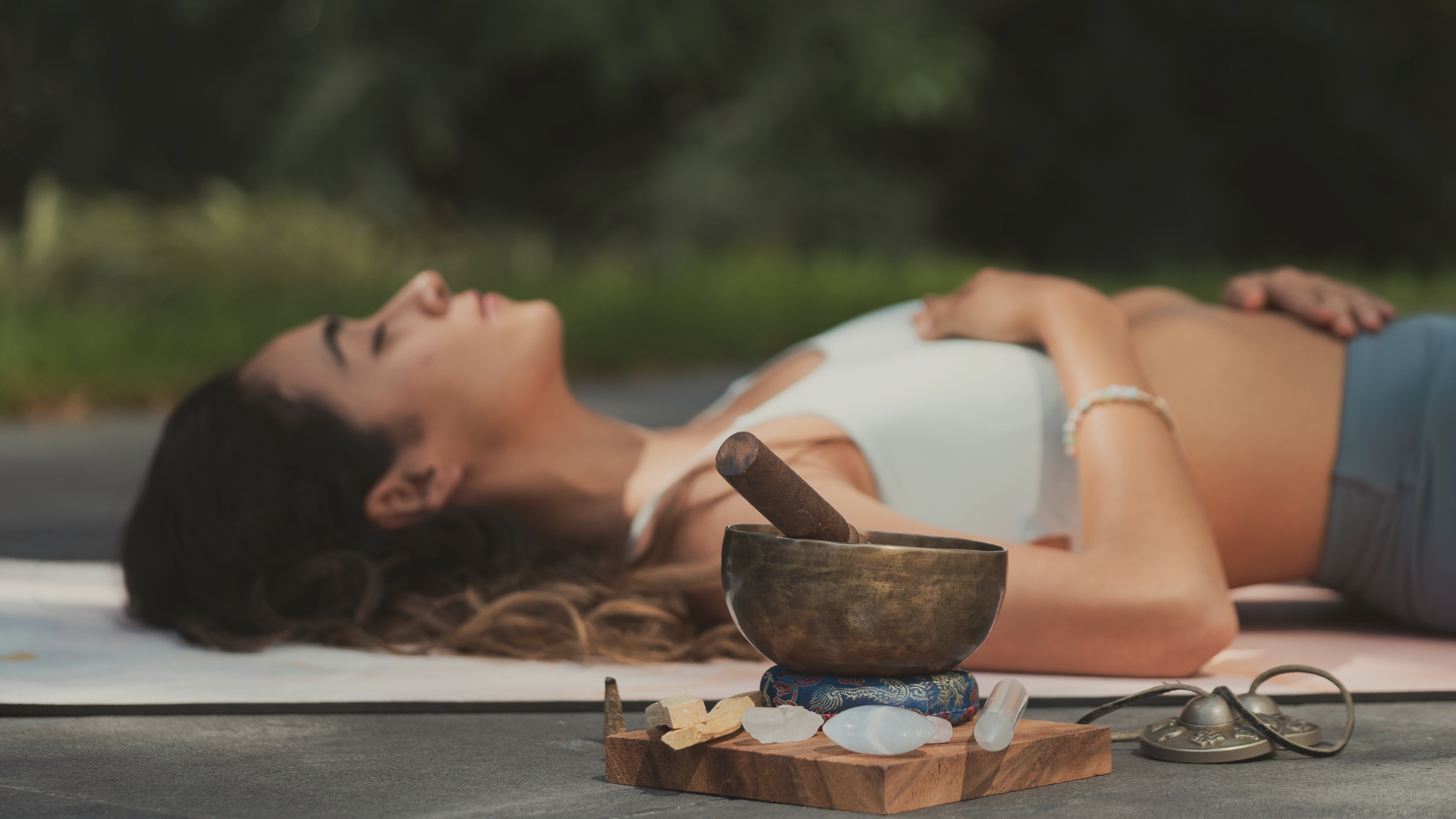 Femme allongée pendant une séance de breathwork avec un bol tibétain et des cristaux au premier plan