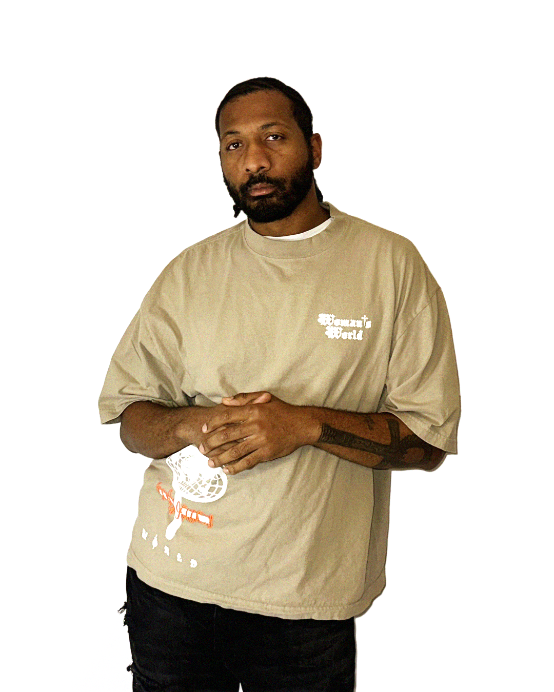 A man with dark hair and beard, wearing a tan Woman's World HARMMONEY* t-shirt with white text on the chest, standing against a plain white background.