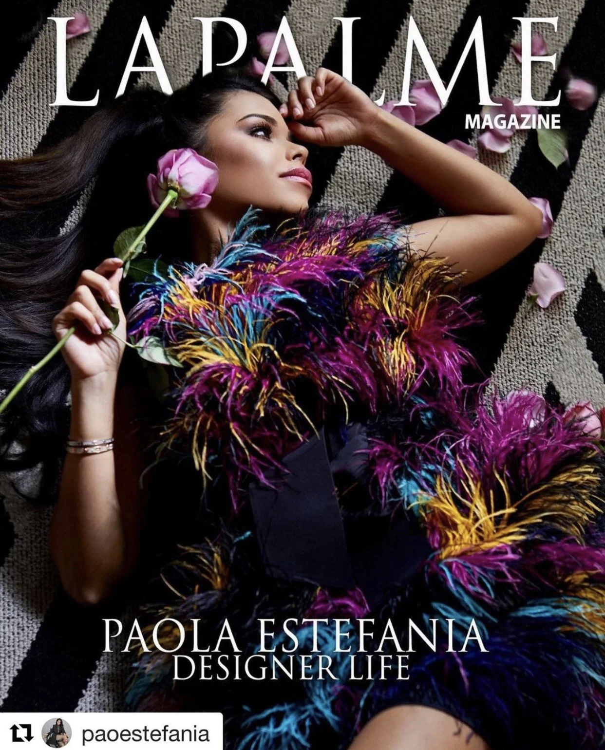 Magazine cover featuring a woman lying on a textured surface, holding a pink rose near her face. She wears a colorful feathered garment with shades of pink, purple, blue, and yellow. The text on the cover reads "LAPALE MAGAZINE" and "PAOLA ESTEFANIA DESIGNER LIFE."