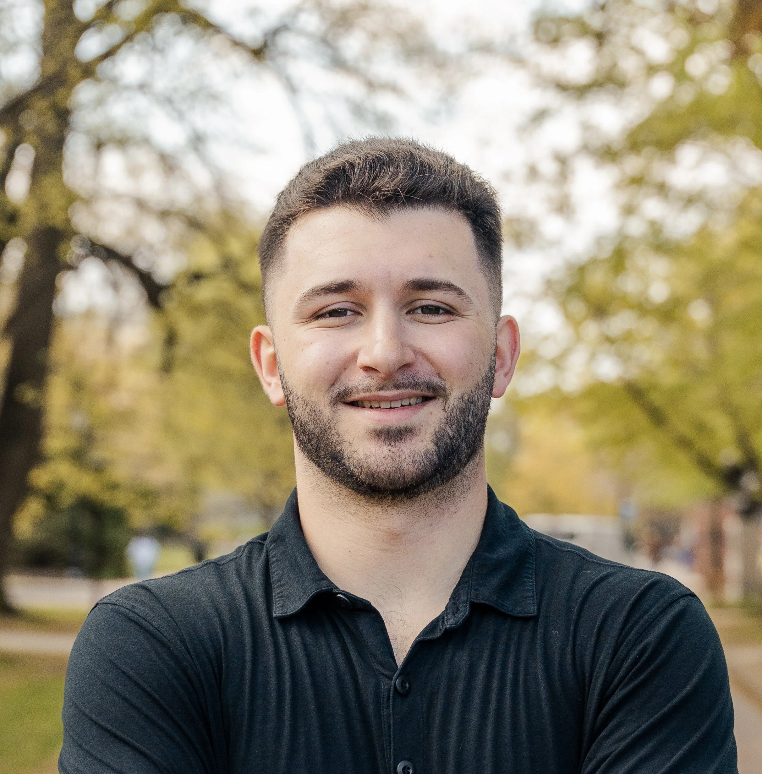 Portrait of Nick Vinacco outdoors in a black polo shirt