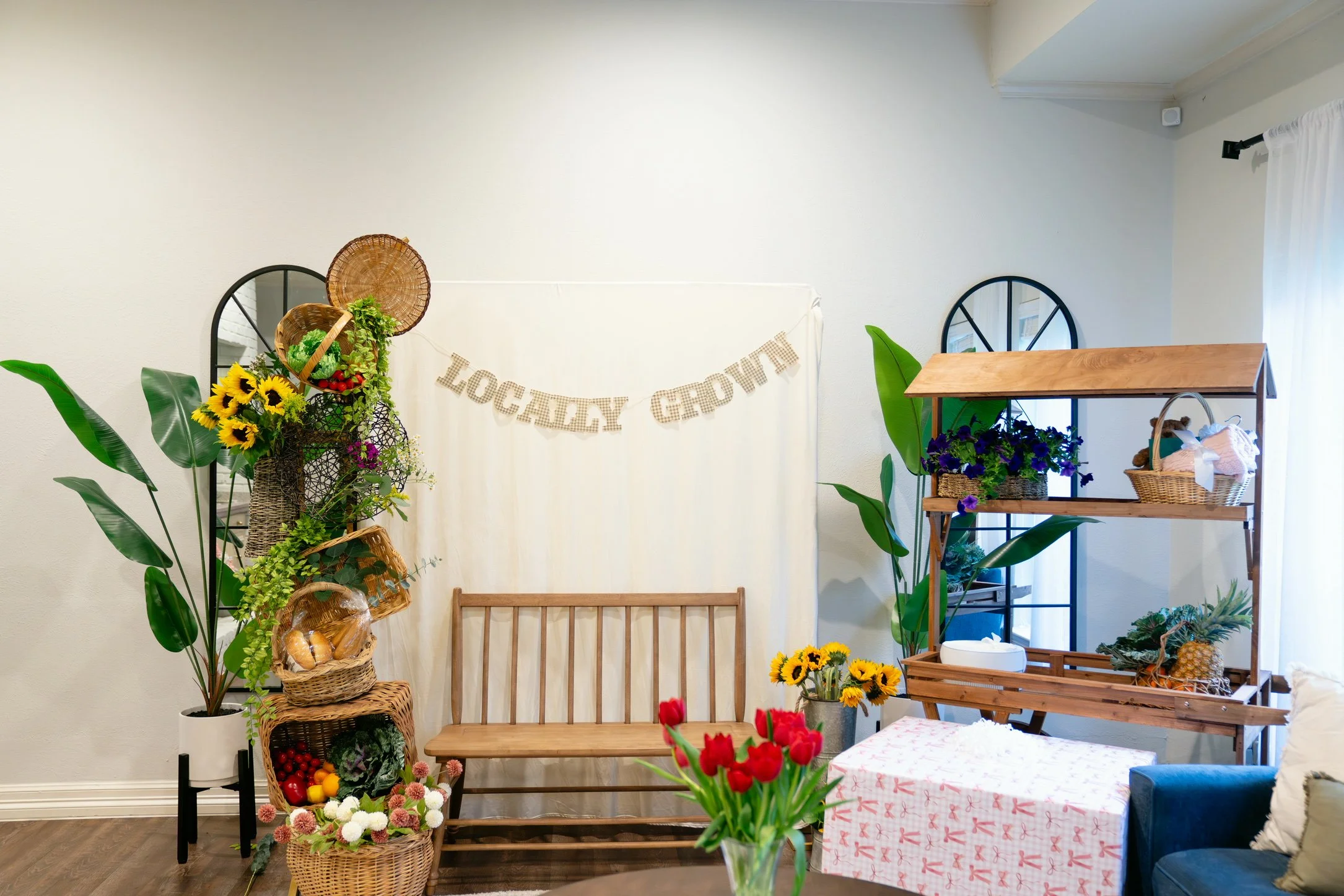Indoor scene decorated with flowers, plants, and rustic furniture, with a banner reading 'LOCALITY GARDEN' on the wall.