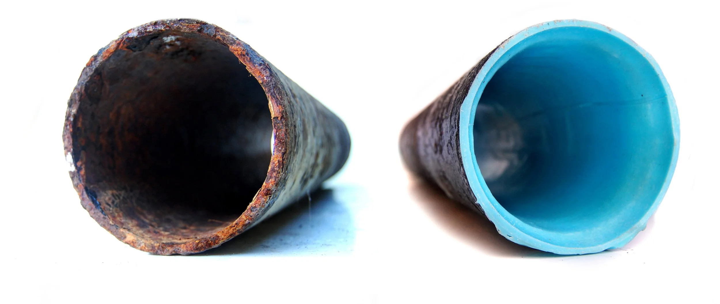 A rusty, corroded metal pipe on the left and a clean, smooth plastic pipe with a blue interior on the right, positioned side by side.