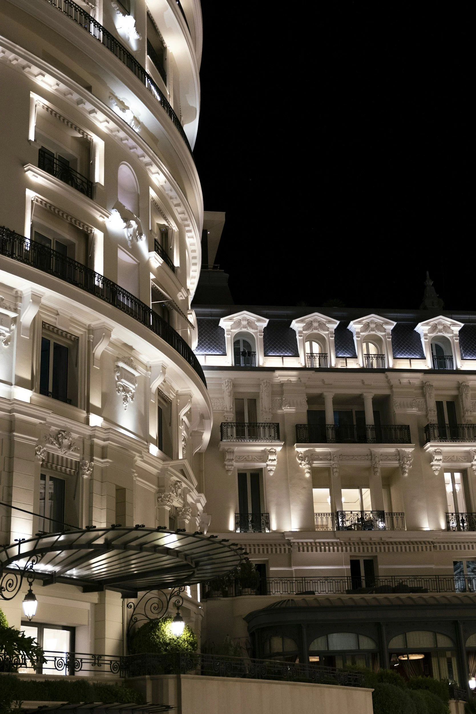 Grand hotel facade lit at night, hospitality real estate advisory