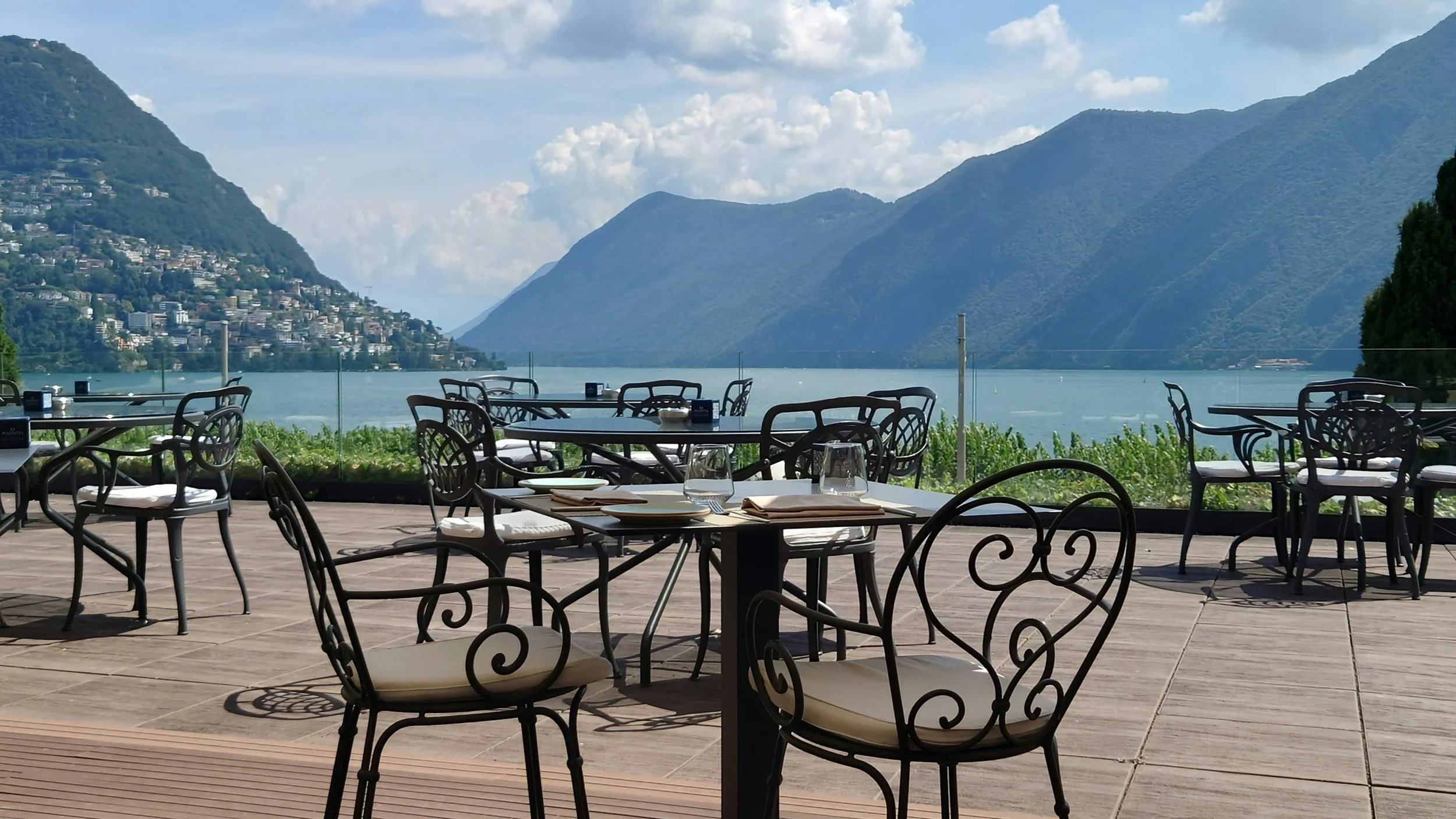 Lakeside hotel restaurant terrace with mountain views, luxury hospitality asset