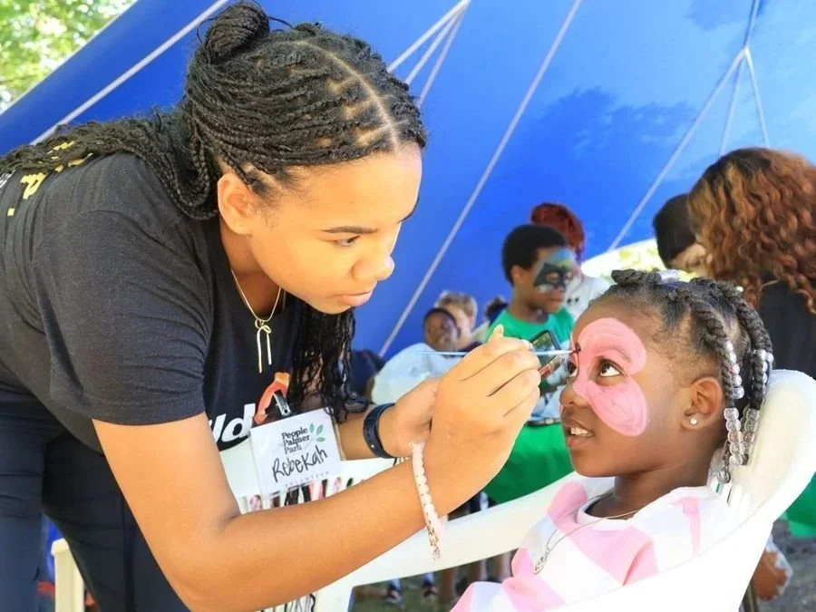 Child getting her face painted at a festival