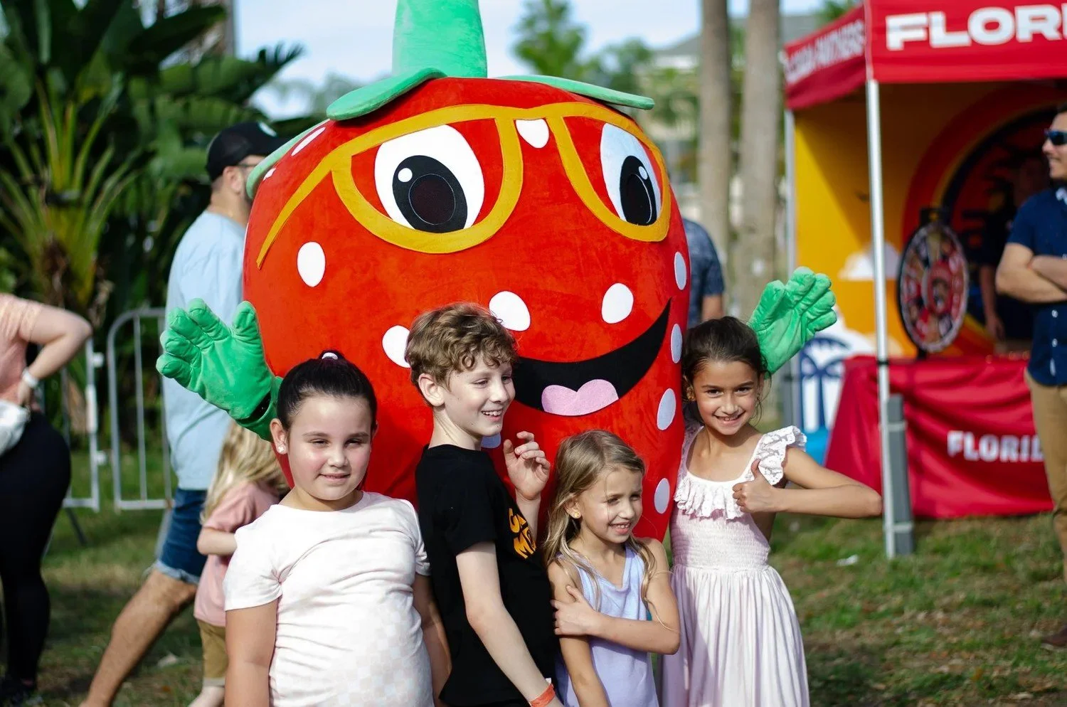 Kids posing with the strawberry mascot