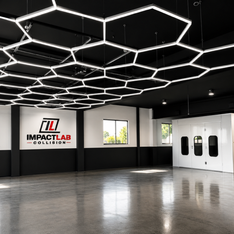 Interior of Impact Lab Collision with hexagonal LED ceiling lights, black and white walls, and a double door entrance.