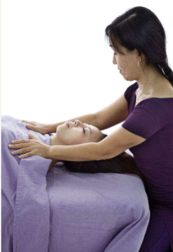 Yasue Tanaka providing biodynamic craniosacral therapy to a client resting on a treatment table in San Rafael, California.