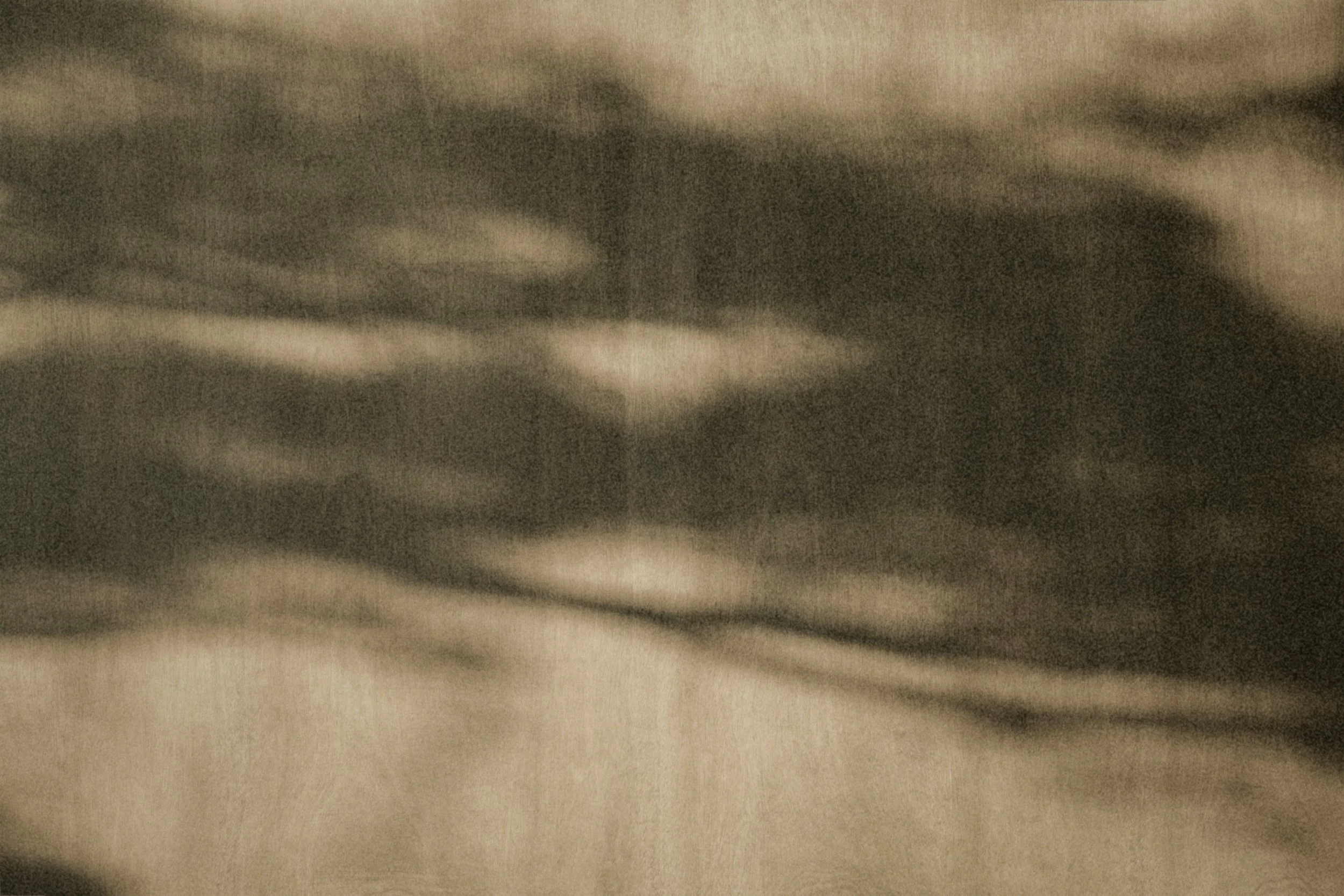 Close-up view of a textured fabric surface with a pattern of light and dark tones, possibly a piece of cloth or upholstery.