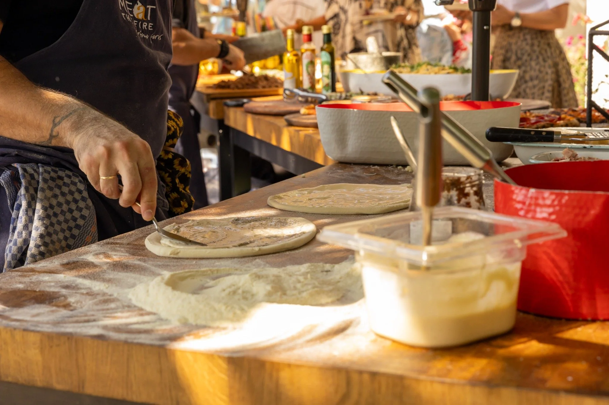 Preparing pizza dough with fresh ingredients at the workbench.