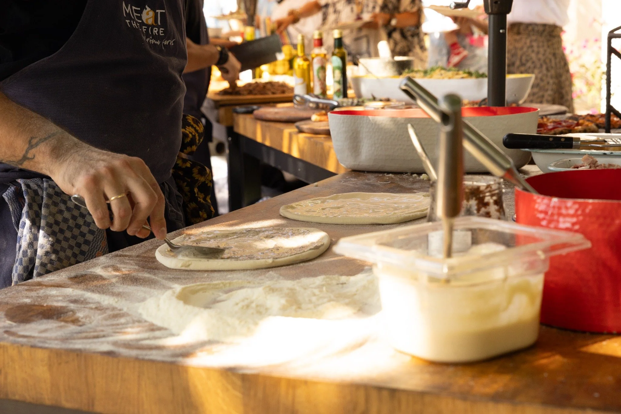 Hands-on pizza preparation with dough and toppings.