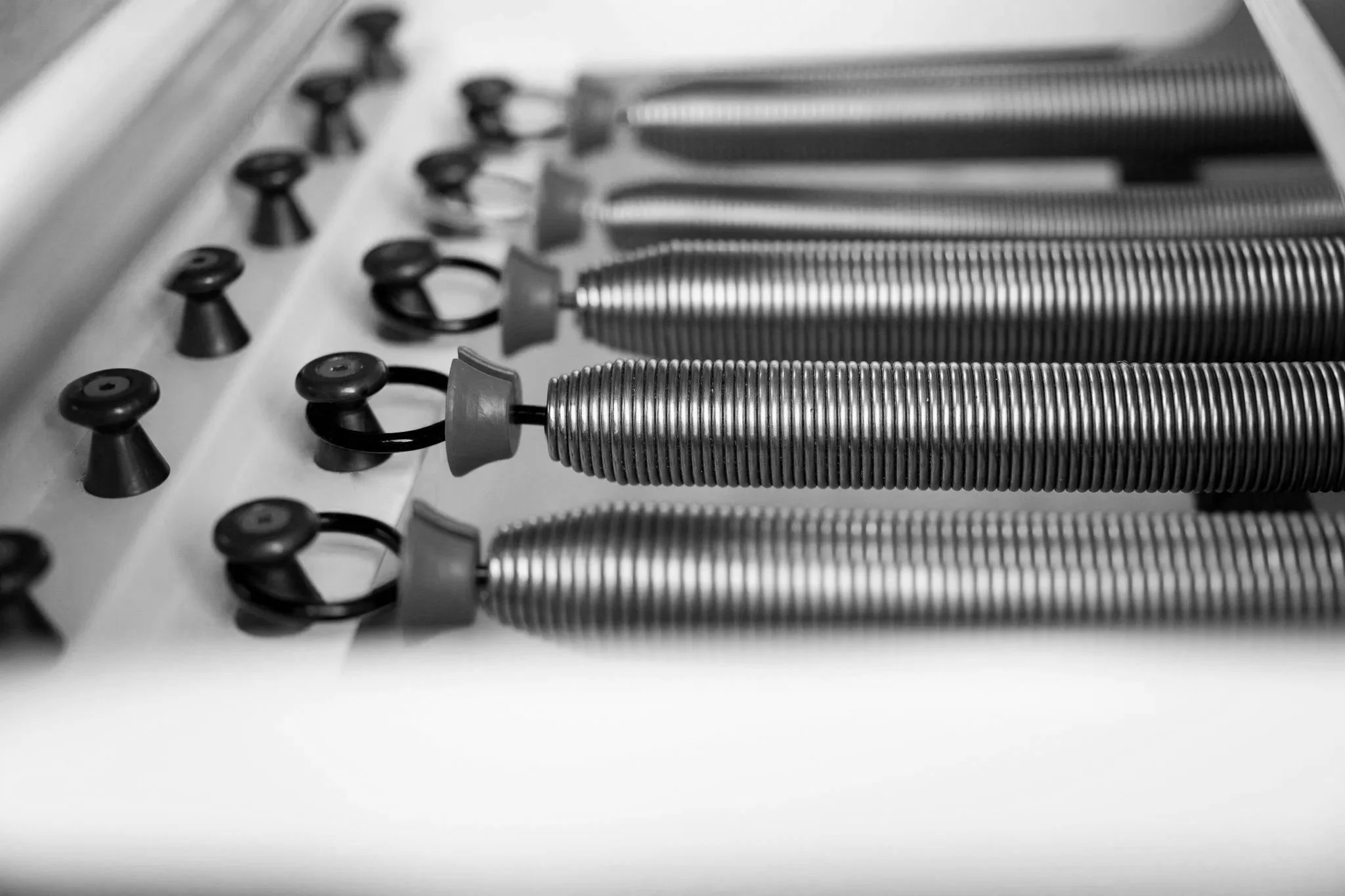 Close-up of metal components and screws on a metallic surface, with a blurred background.