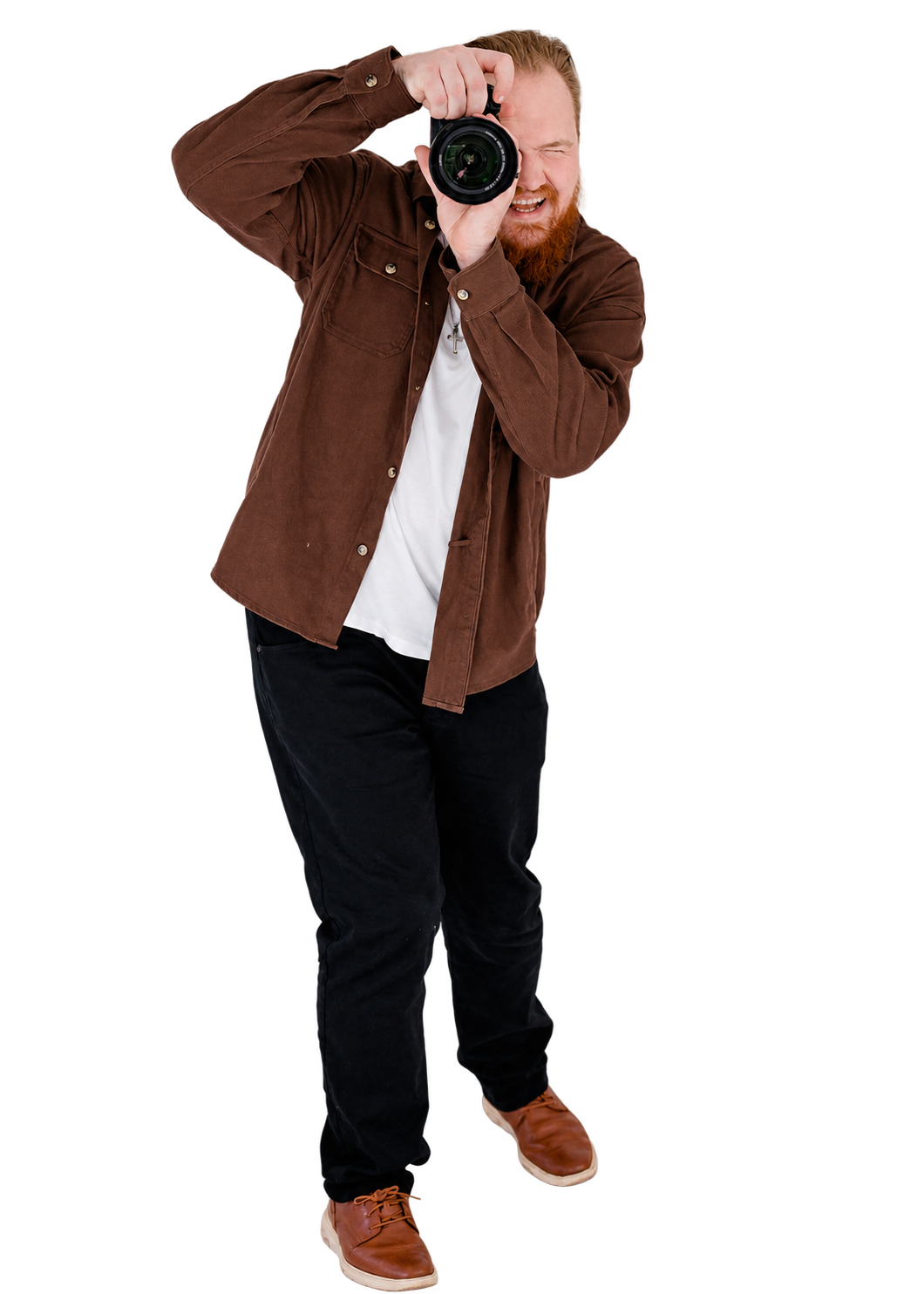 A man with red hair and a beard taking a photo with a professional camera, wearing a brown jacket, white t-shirt, black pants, and brown shoes.