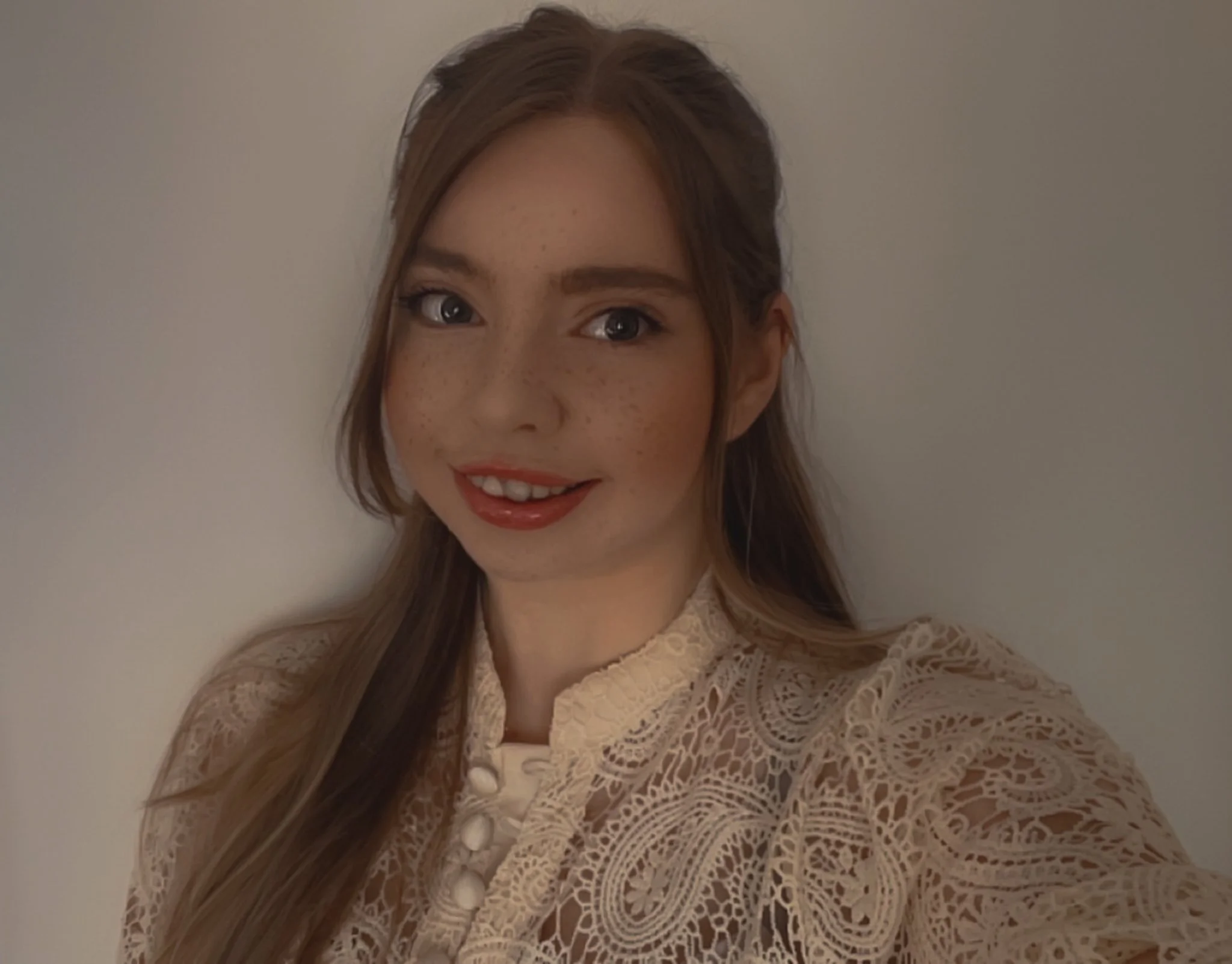 Jade, the photographer behind Luminous Shots Photography, smiling in a cream lace blouse.
