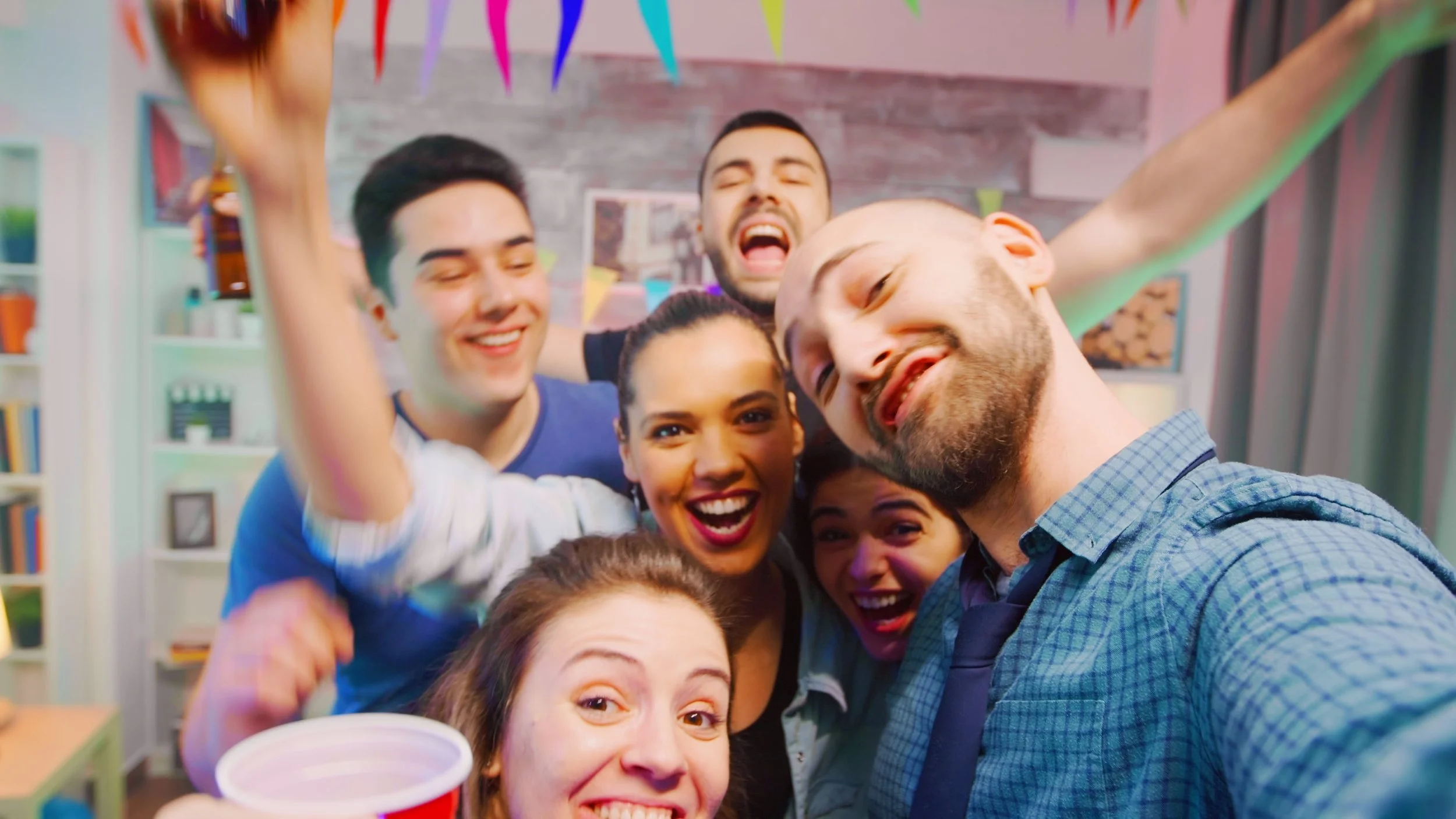 pov-of-cheerful-young-man-in-a-room-partying-with-his-friends-and-inviting-people-to-c-SBI-350780098.jpg