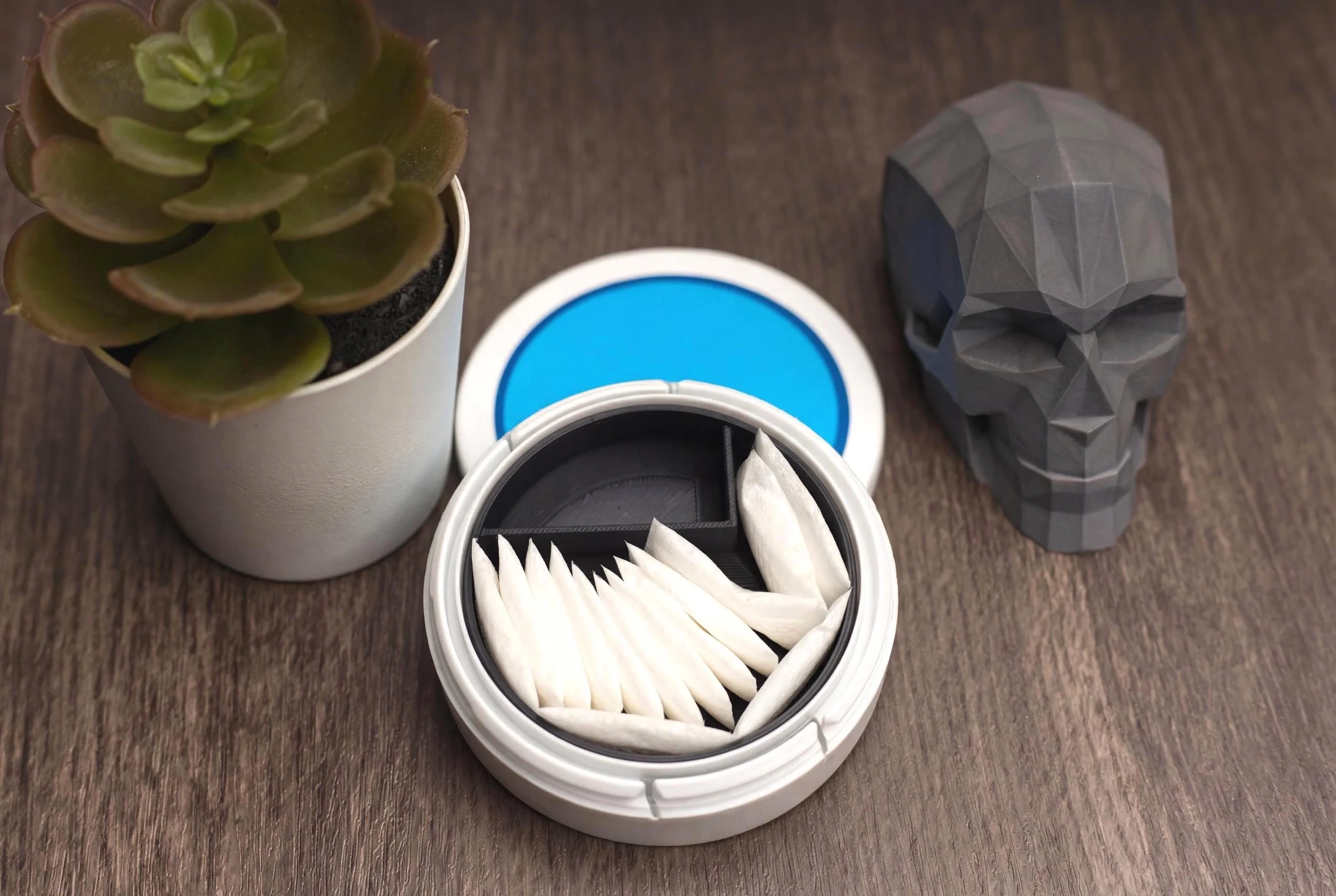 3D-printed tin insert with a blue lid that divides a standard 70mm tin into two compartments for nicotine pouches