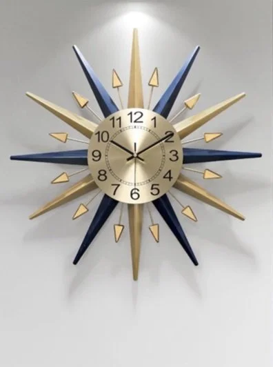 Mid-century starburst wall clock with gold and navy sun rays and a cream face