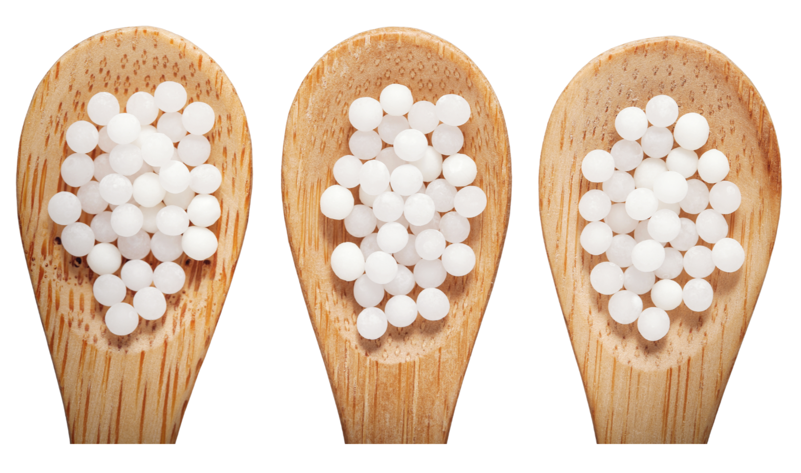 Three wooden spoons filled with white tapioca pearls, arranged side by side.
