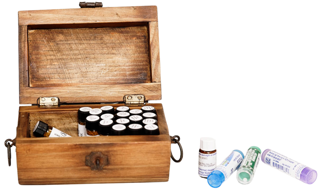 An open wooden box containing small bottles with white caps inside, and several bottles outside the box, some with blue, green, and purple caps.