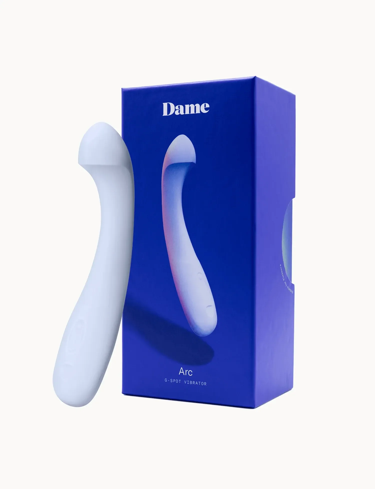 A white G-spot vibrator labeled 'Arc' stands next to its blue packaging box with the word 'Dame' on top. The box also has the text 'G-SPOT VIBRATOR' and 'Arc' near the bottom.