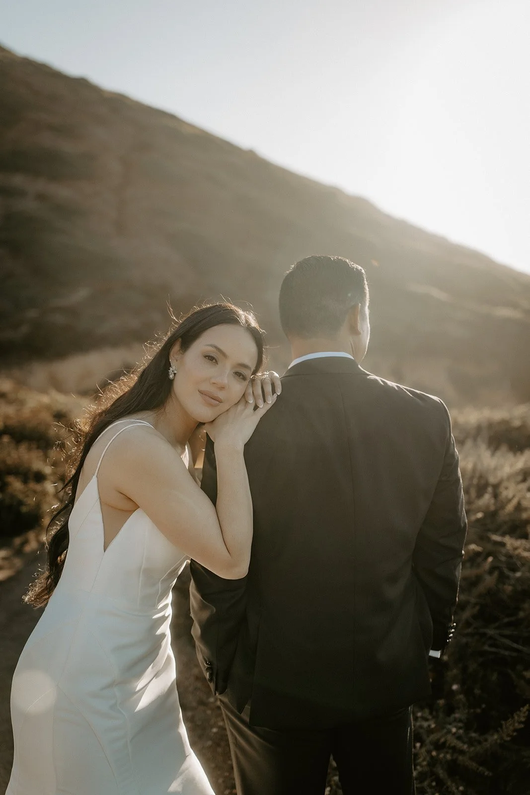 Bride resting her her husbands shoulder in big sur right after they tied the knot.