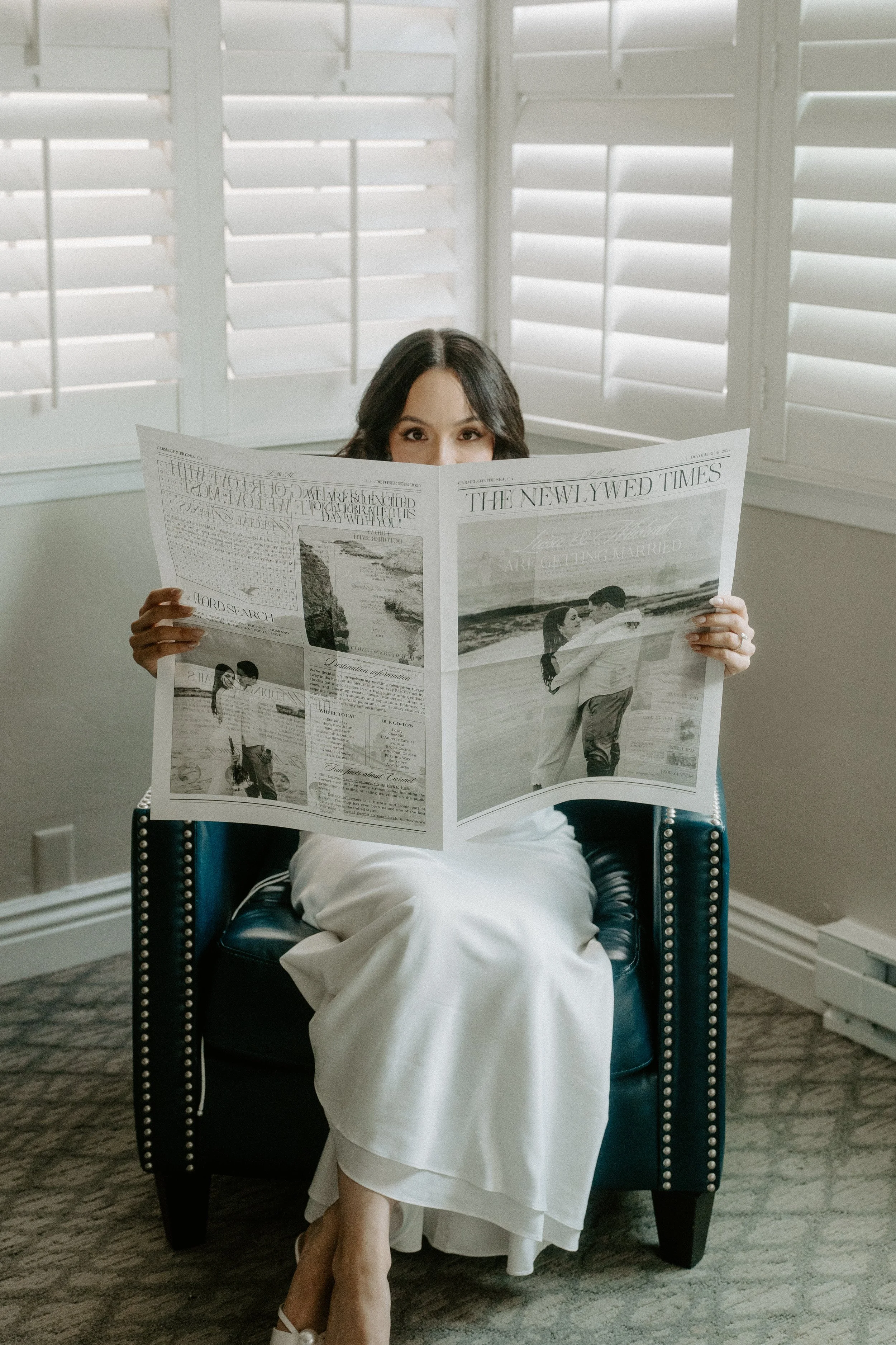 Bride peaking her eyes over a newspaper that reads " The Newlyweds Times".