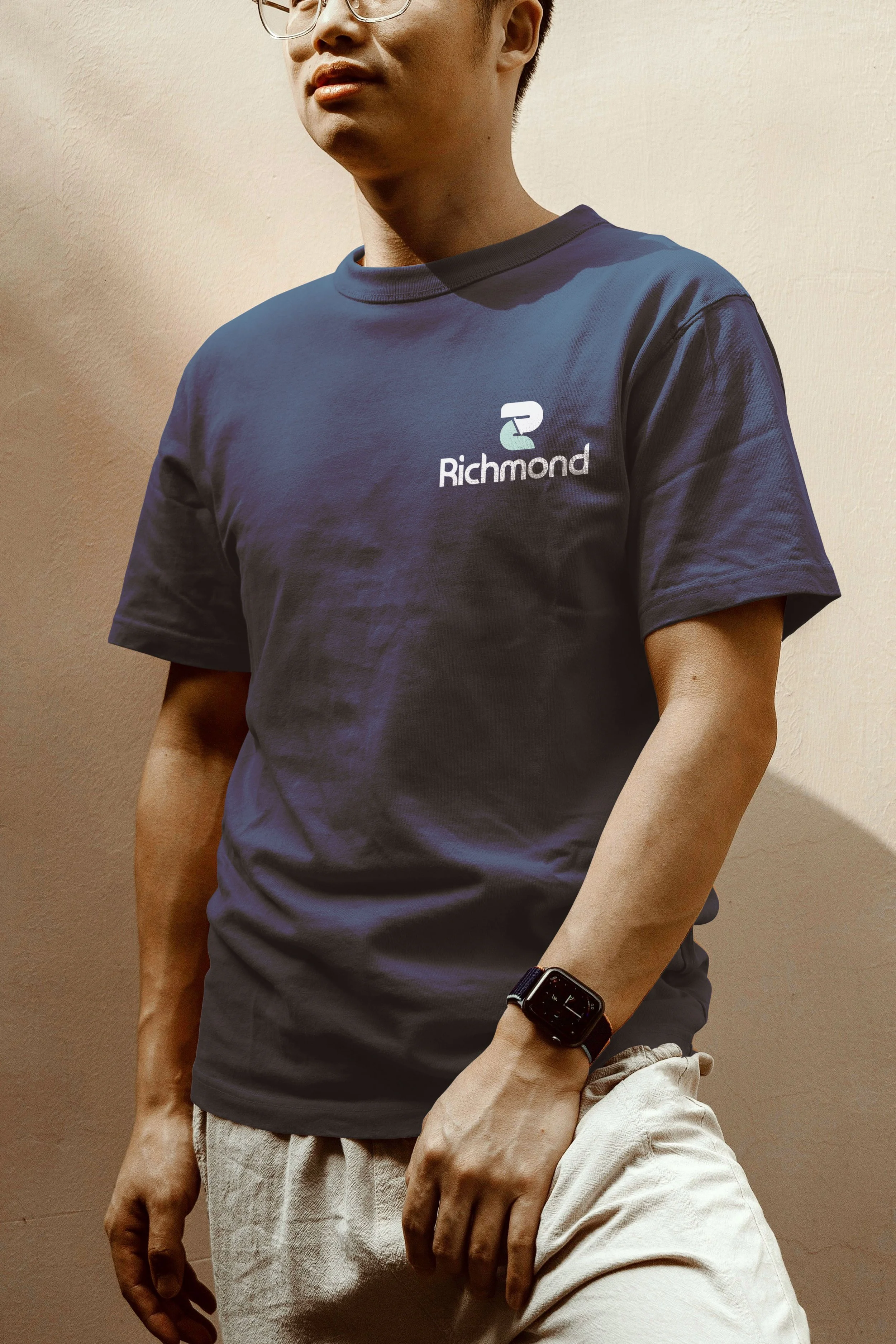 Person wearing glasses and a navy Richmond T-shirt, white shorts, and a smartwatch