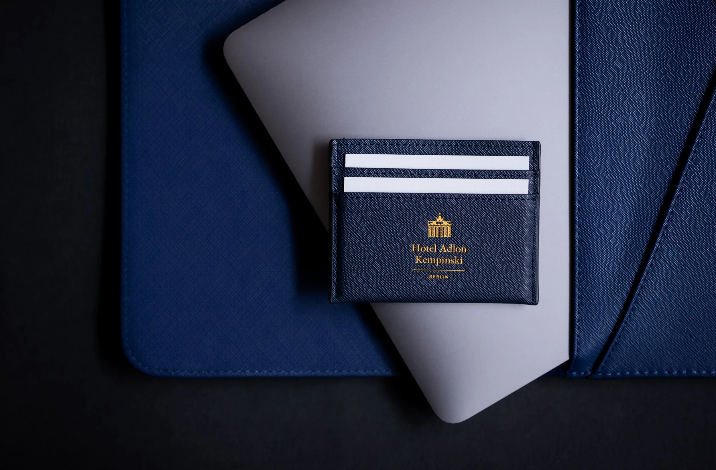 Dunkelblauer Hotelordner mit Log logo des Hotel Adlon Kempinski Berlin auf weißem Papier
