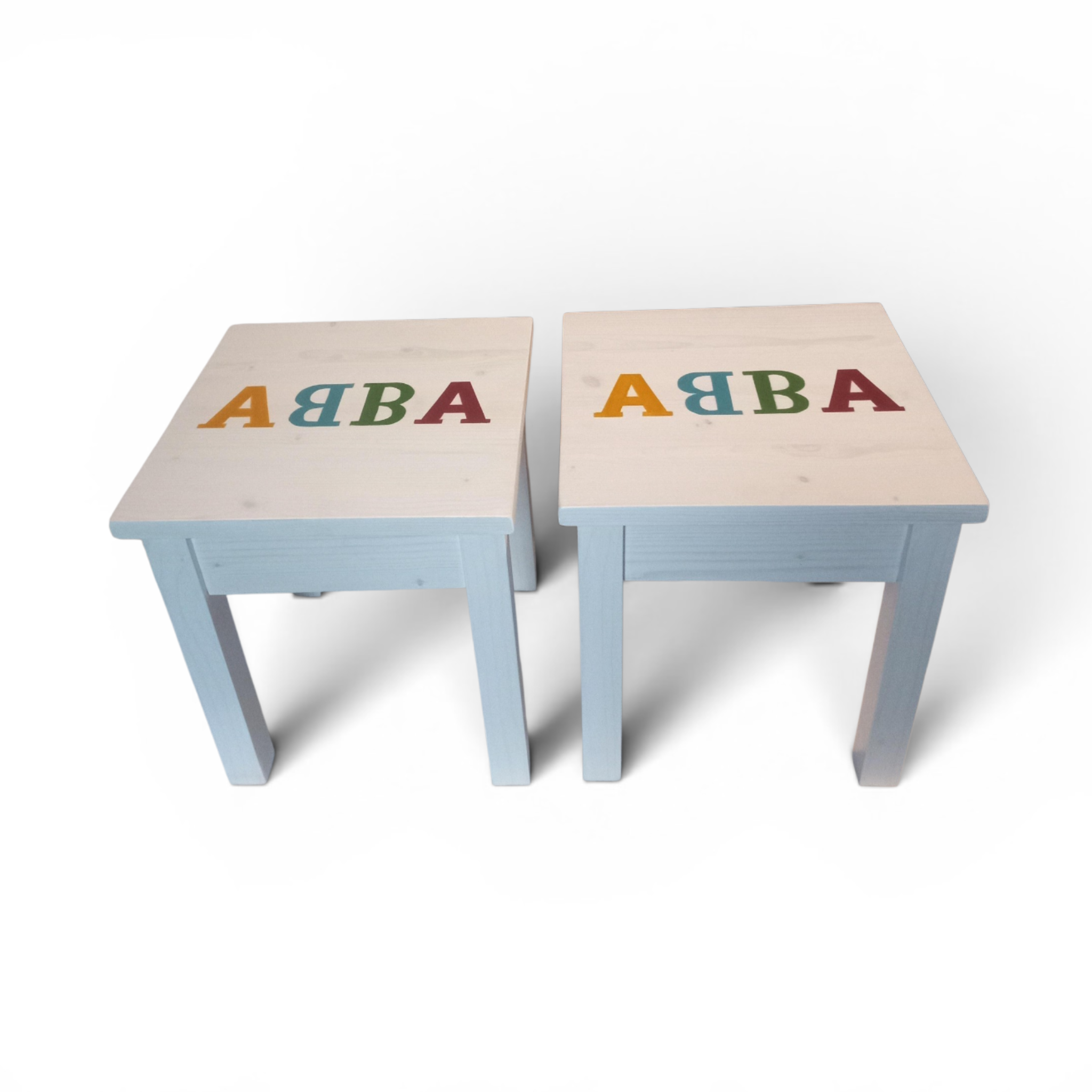 ABBA side tables – light top, colorful letters, matching pair.