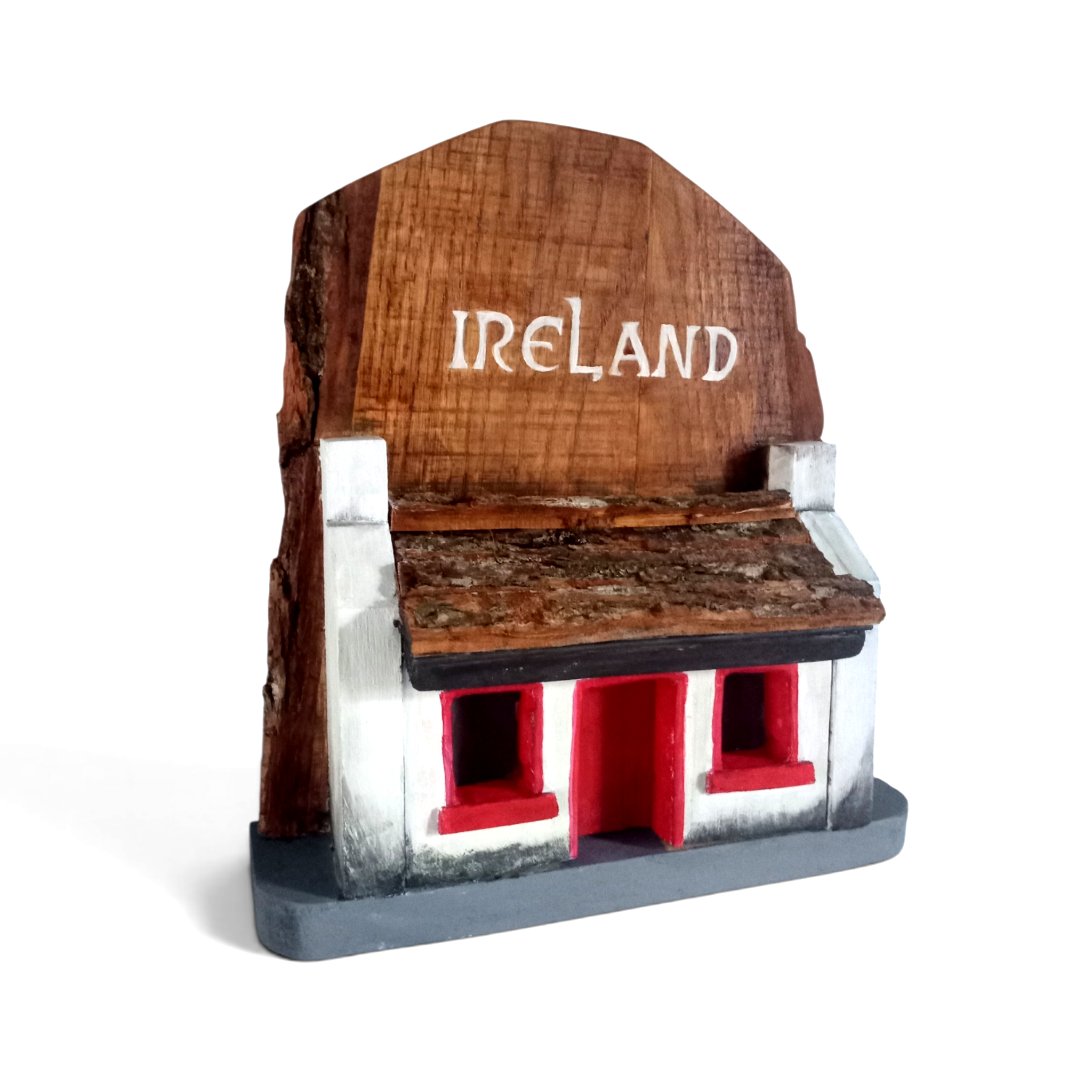 Irish cottage on wood – hand‑carved cottage, natural wood with red accents.