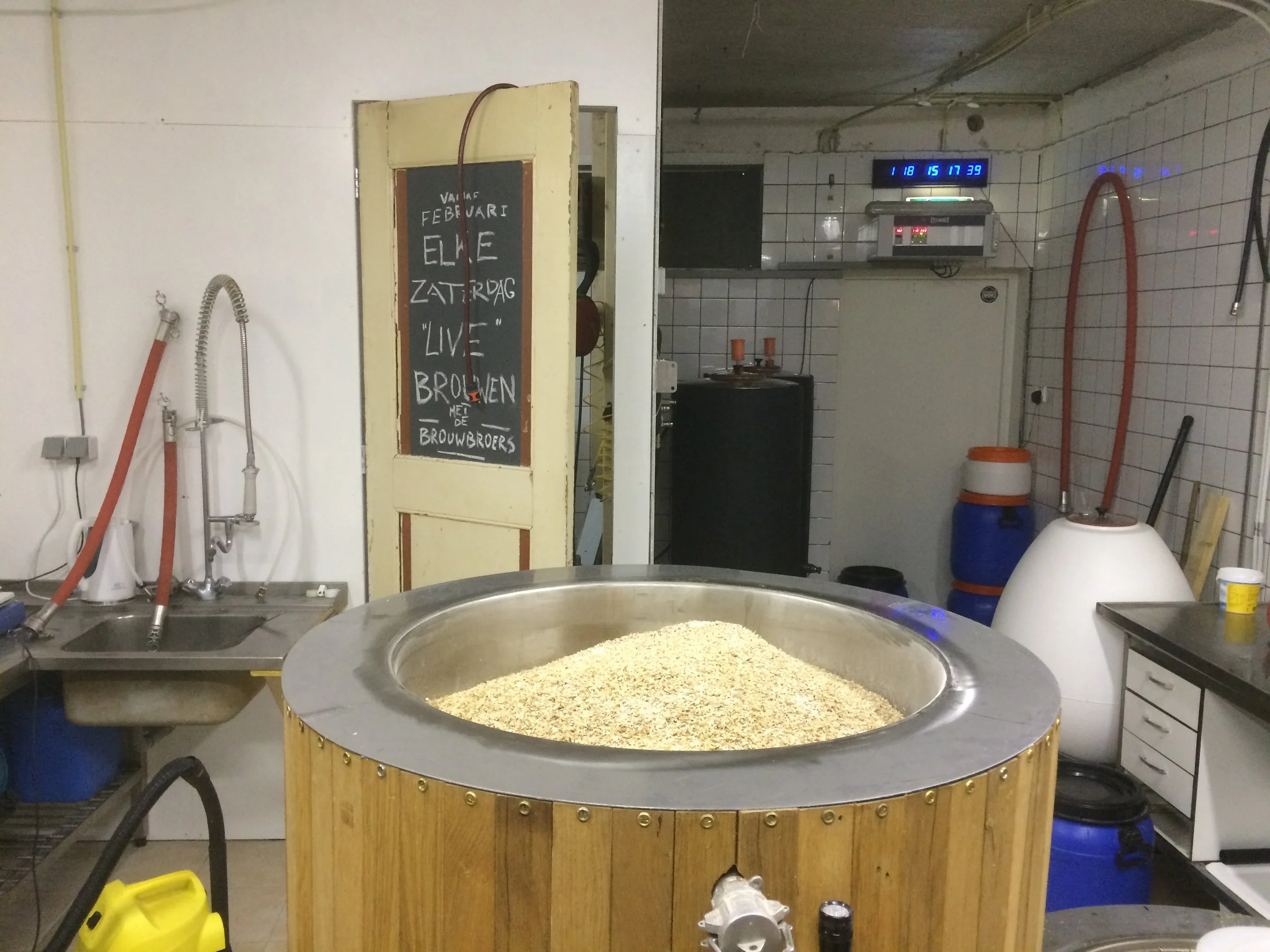 Een grote ronde bak gevuld met gist, omringd door verschillende werkbanken en apparatuur in een bakkerij of brouwerij.