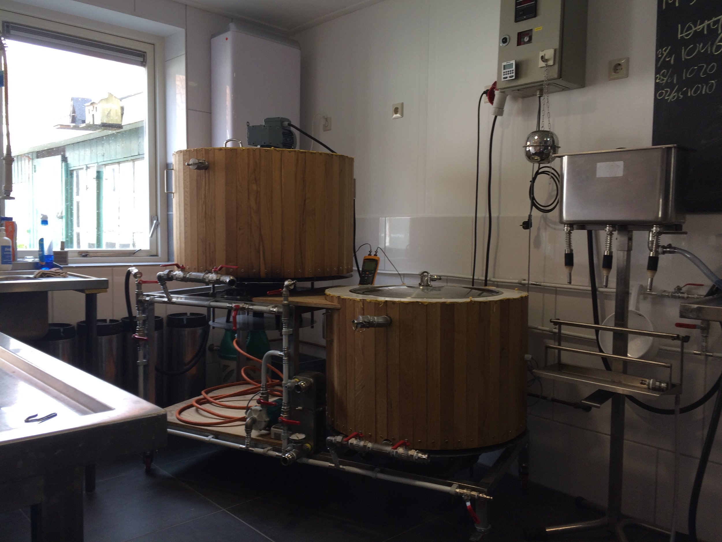 Een binnenbeeld van een laboratoriumruimte met een houten emmer en diverse meet- en regelapparatuur.