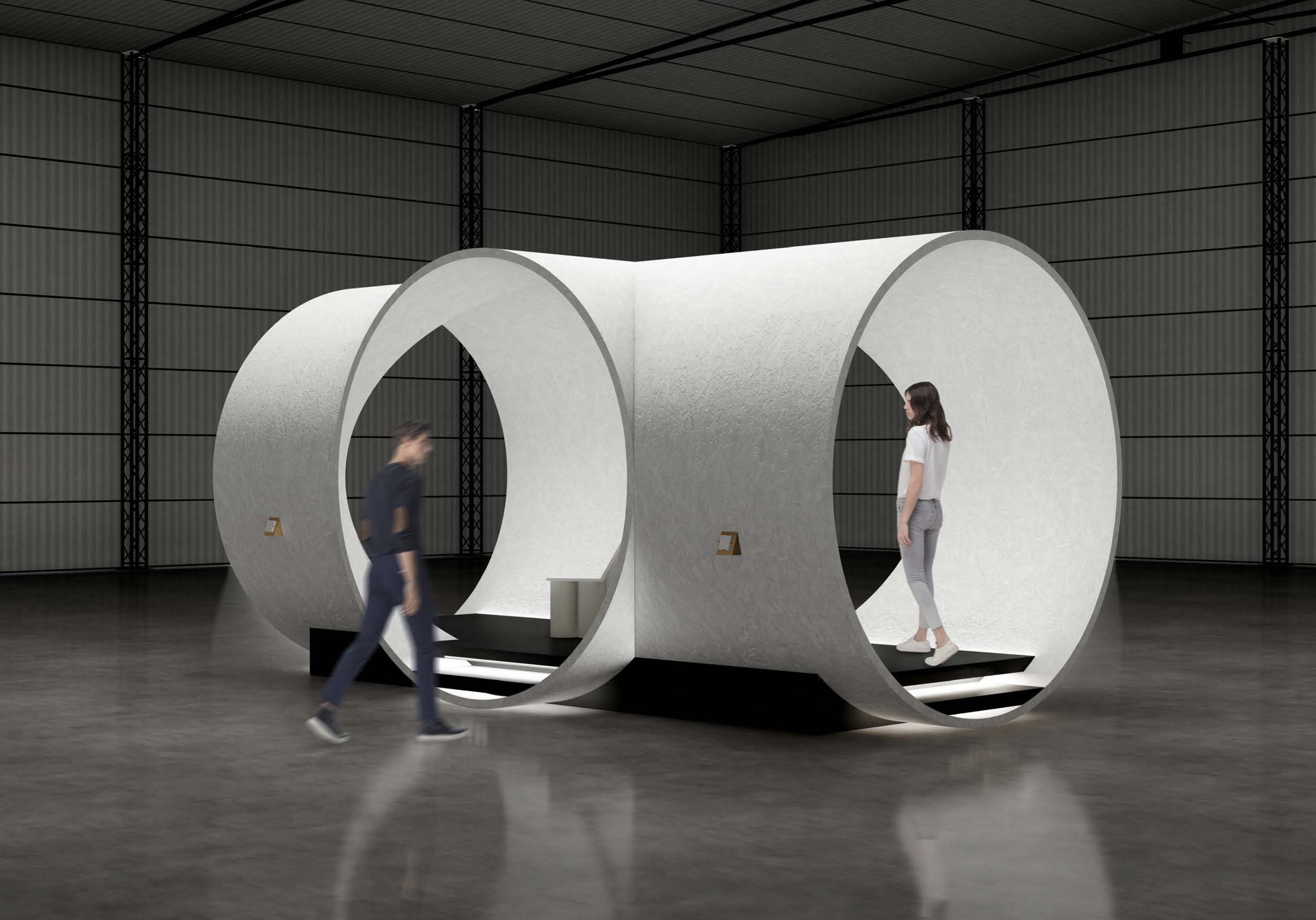 A modern indoor space with large cylindrical white structures and two people, one woman and one man, standing and walking near them, with a black elevated platform and a gray corrugated wall in the background.