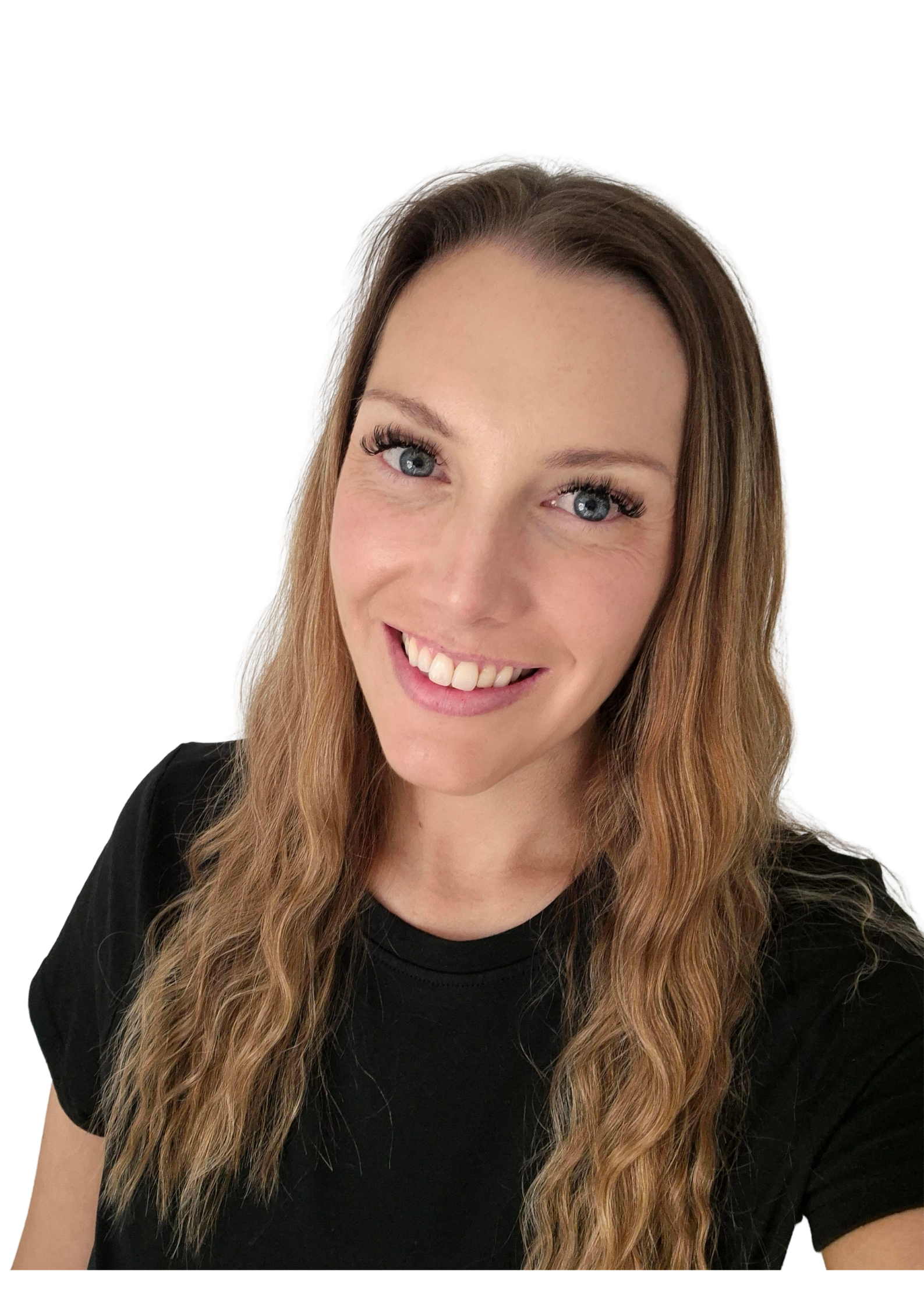 A smiling woman with long wavy ginger hair, wearing a black top, against a black background.