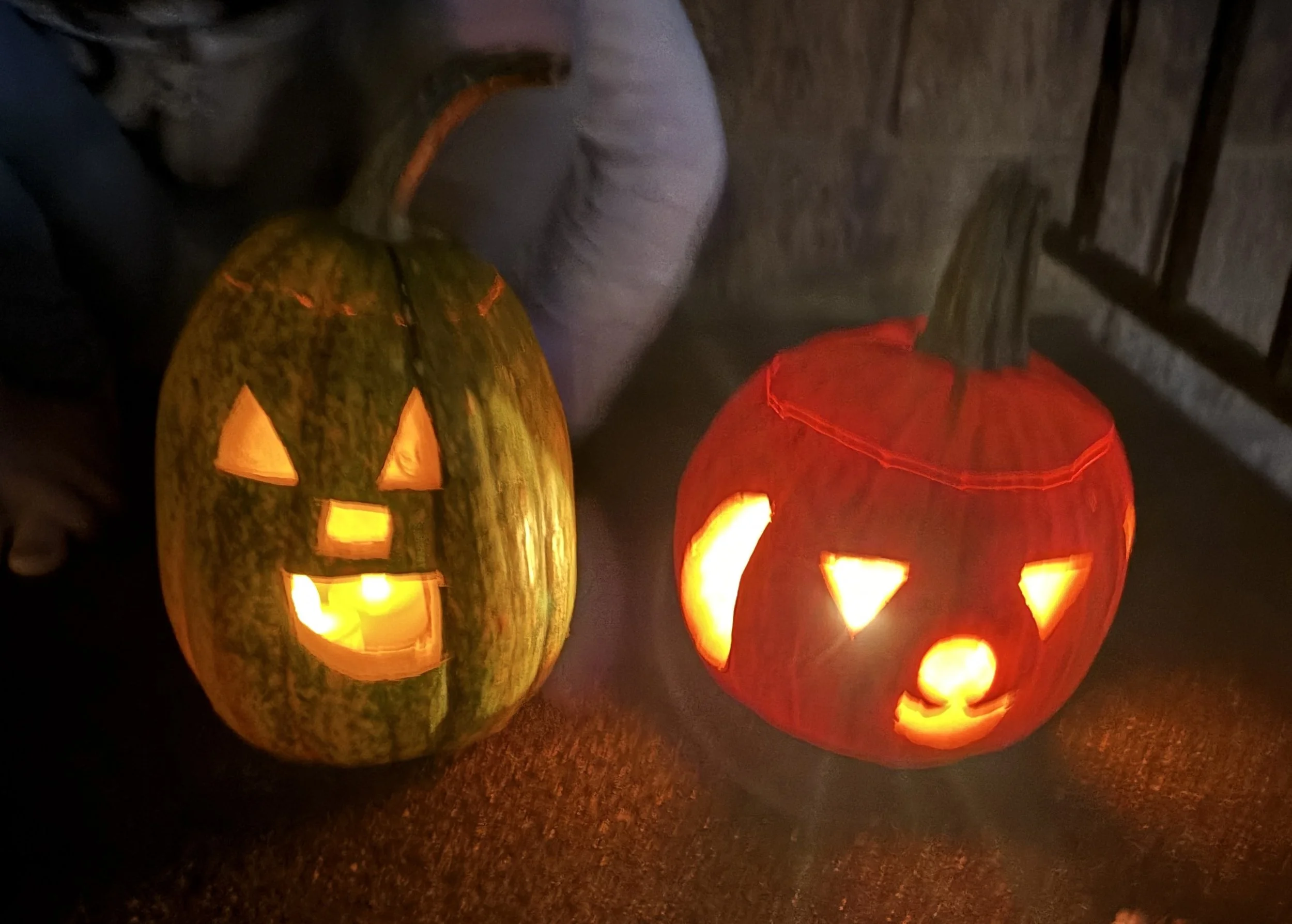 Two glowing jack-o-lanterns at night