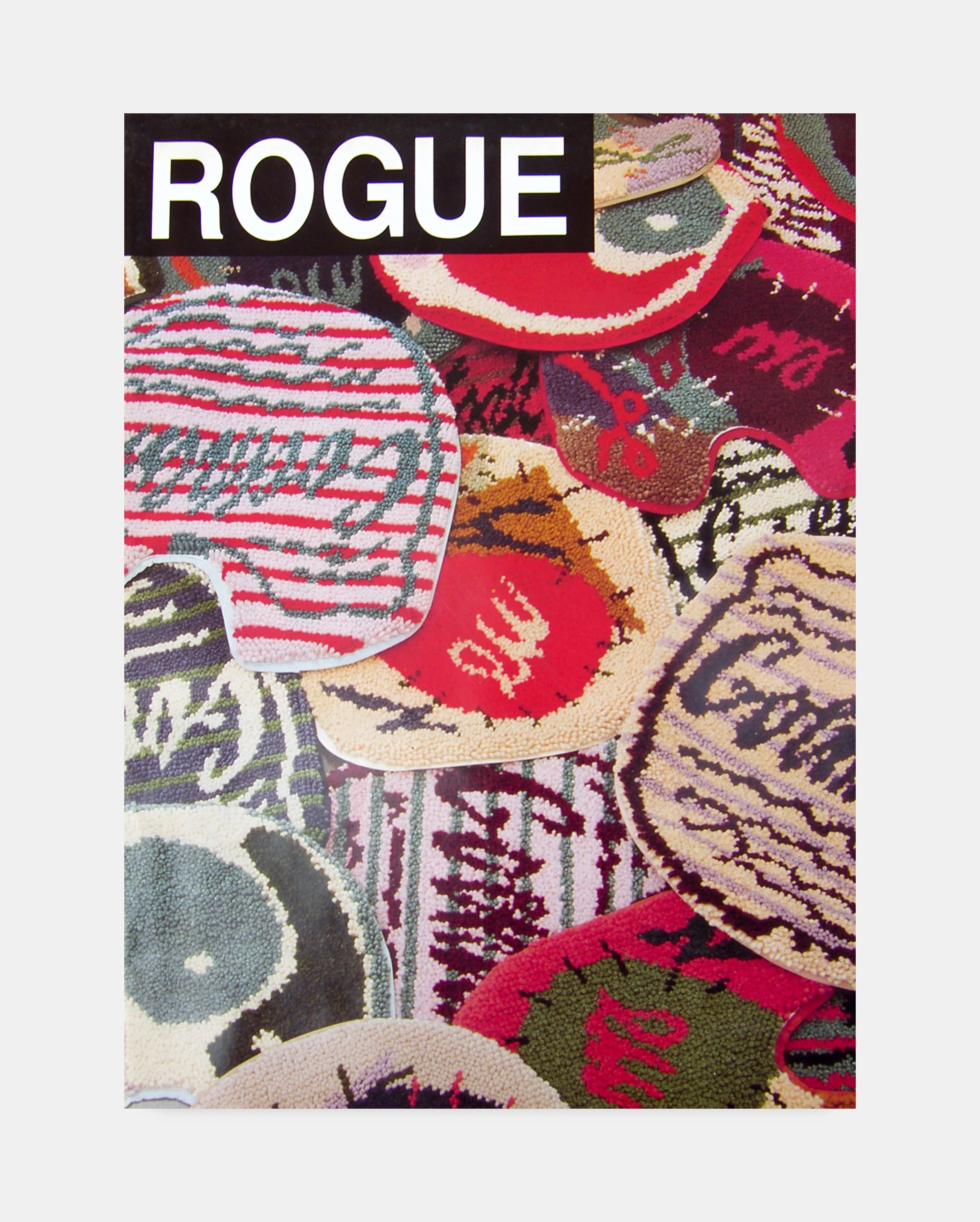 Colorful embroidered rug with various patterns and the word "ROGUE" prominently displayed in white text on a black background.
