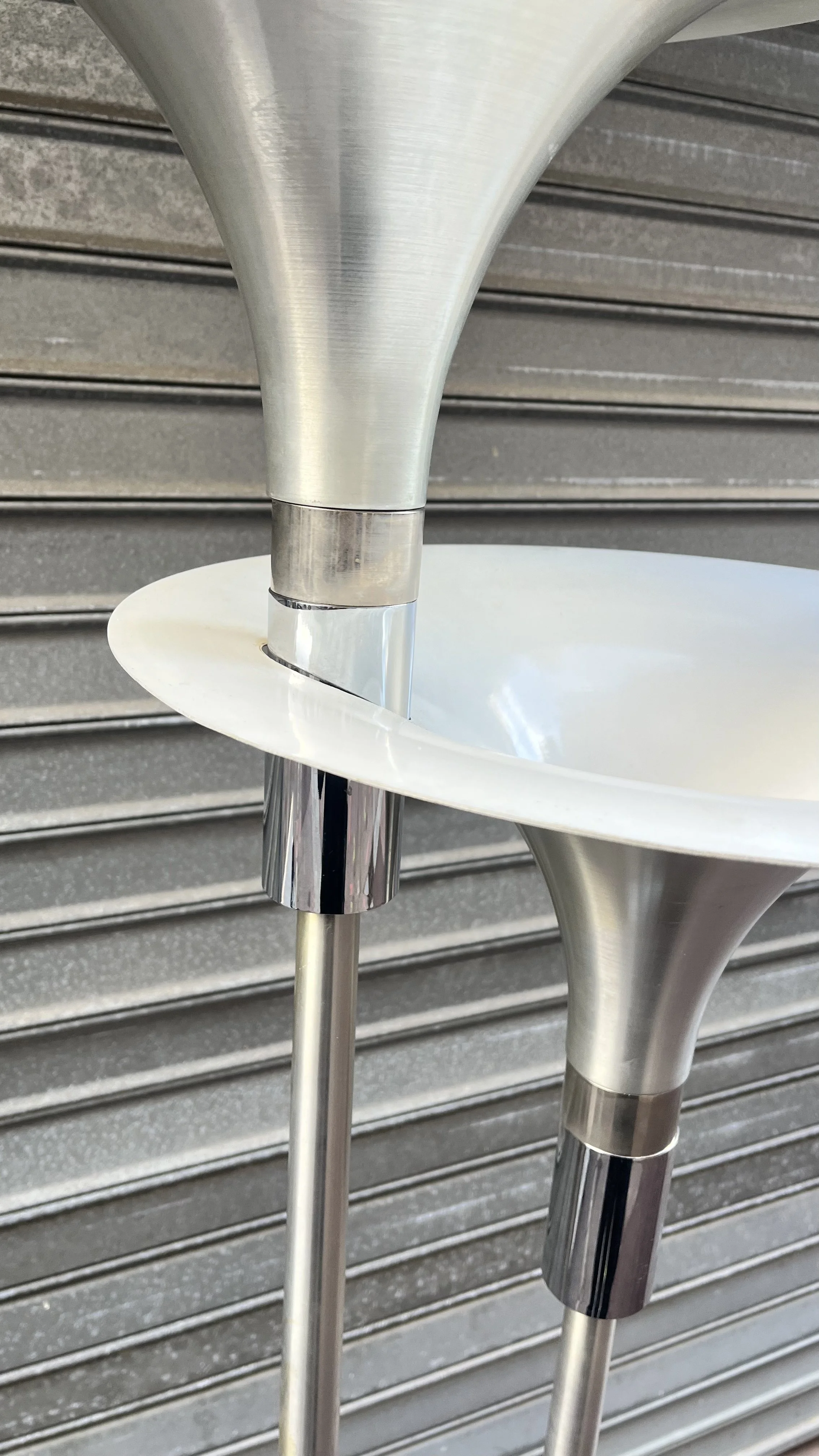 Détail du pavillon en aluminium brossé et des bagues chromées sous les vasques