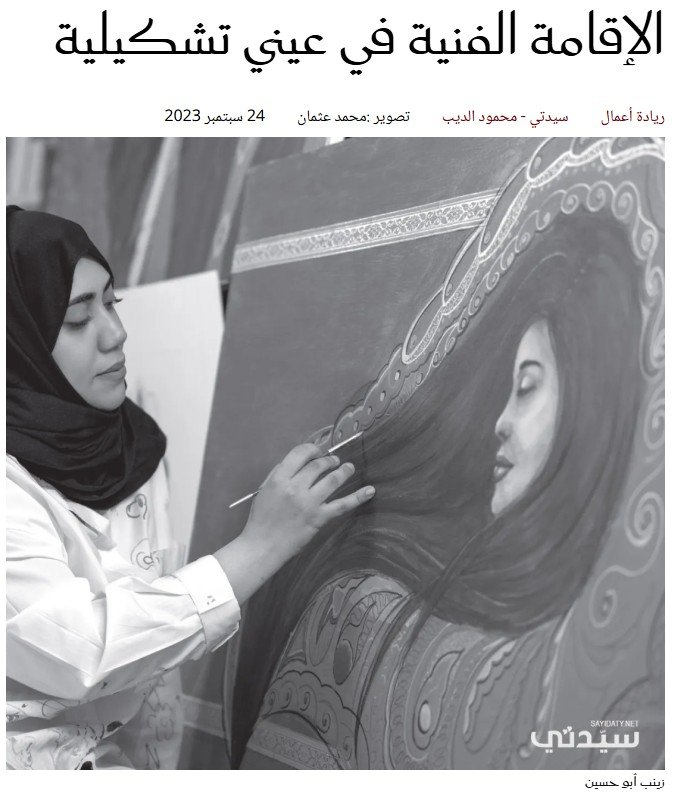 A woman wearing a hijab and white coat painting a woman's portrait on a large canvas.