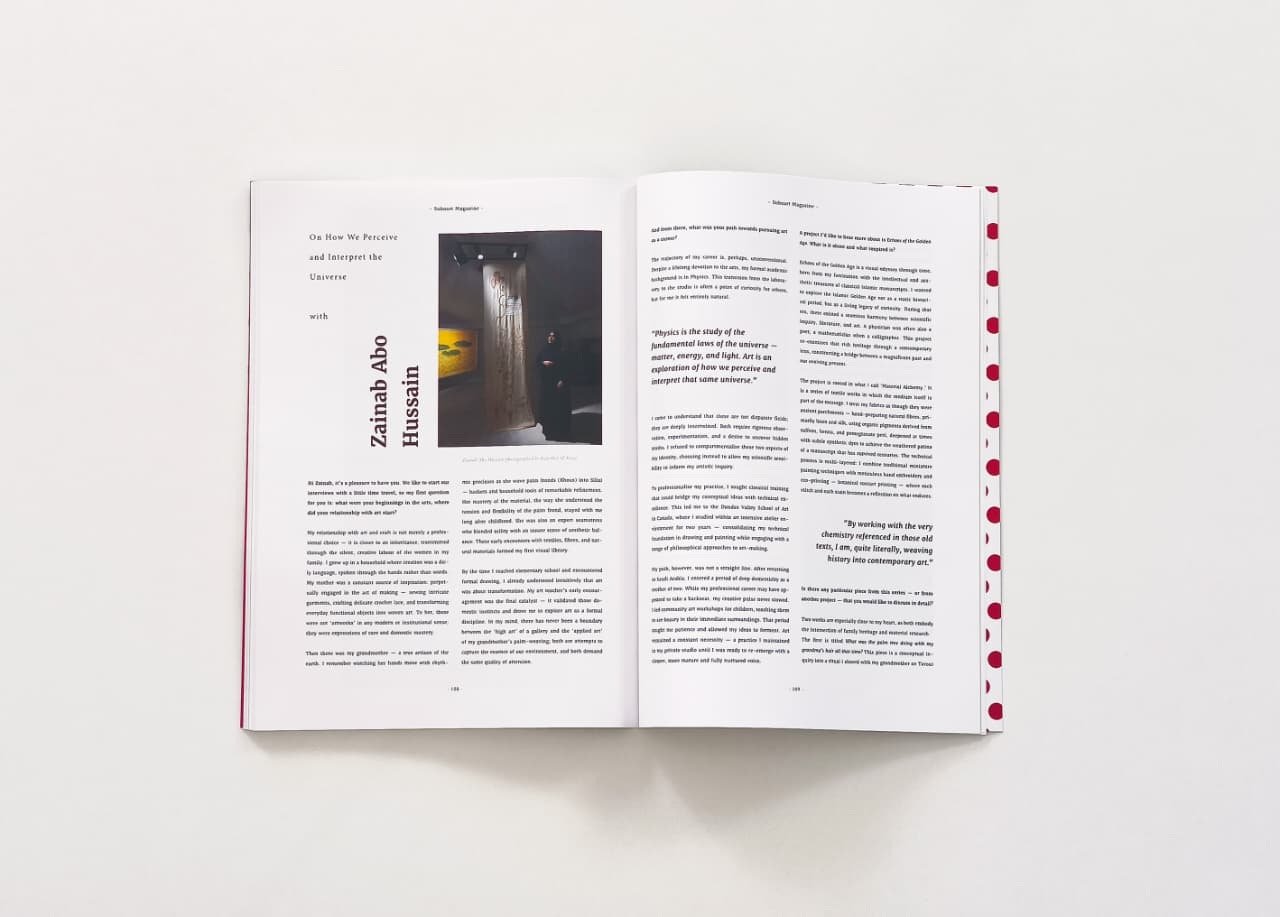 An open magazine lying flat on a white surface, showing two pages filled with text, a photograph, and red polka dot decorative tape on the right edge of the right page.