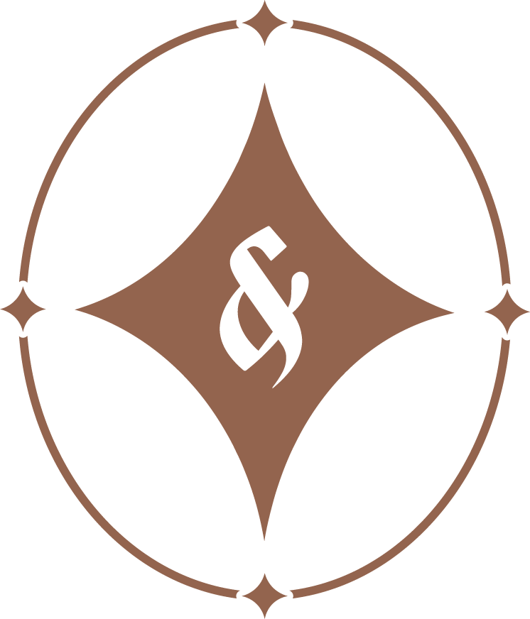 A circular logo with a black and brown color scheme, featuring a stylized ampersand in the center and decorative elements around the border.