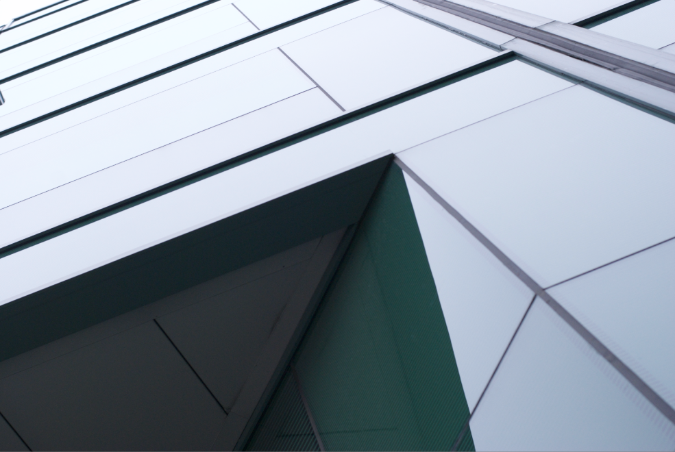Close-up of a modern building with glass and metal panels, showing geometric architectural details.