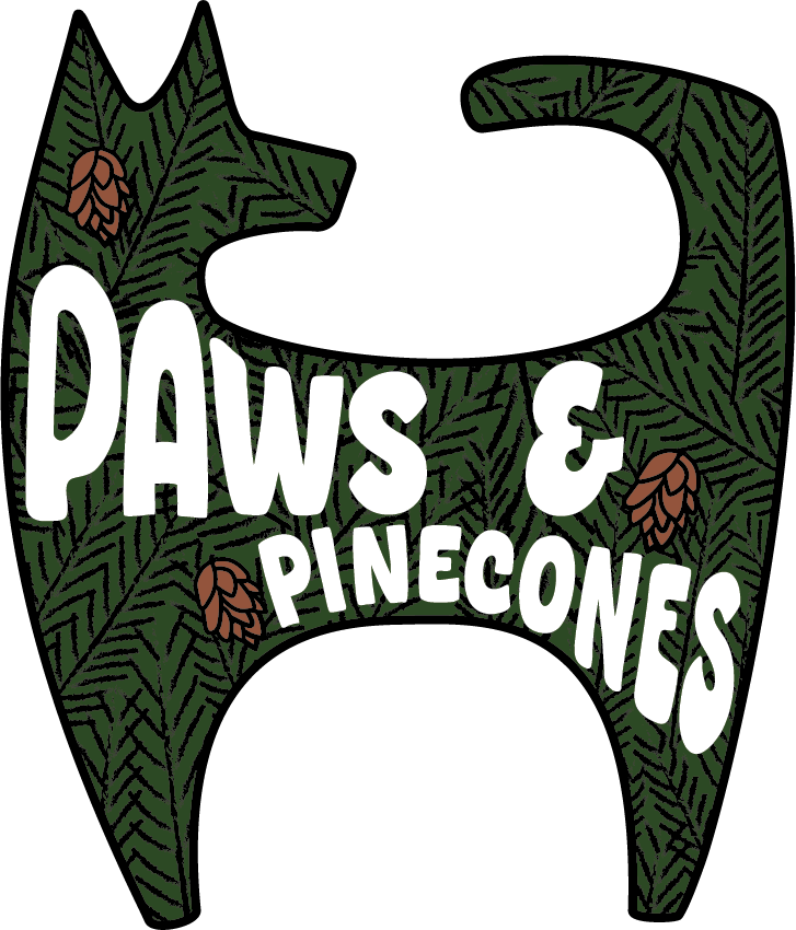 Illustration of a stylized dog shape filled with green pine branches and pinecones, with the text "PAWS & PINECONES" inside.