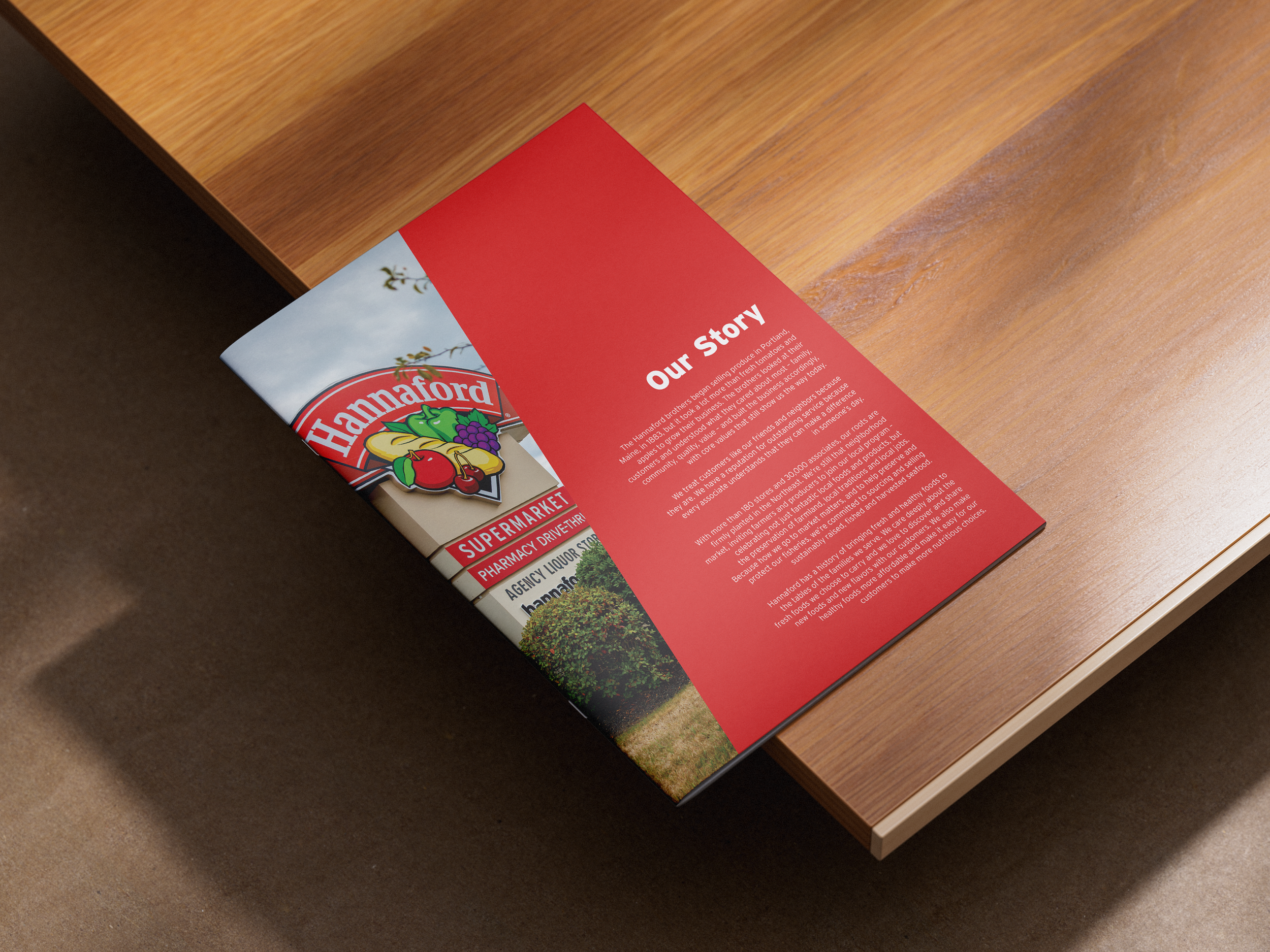 Brochure on a wooden table with a red section titled 'Our Story' and images of fresh produce.