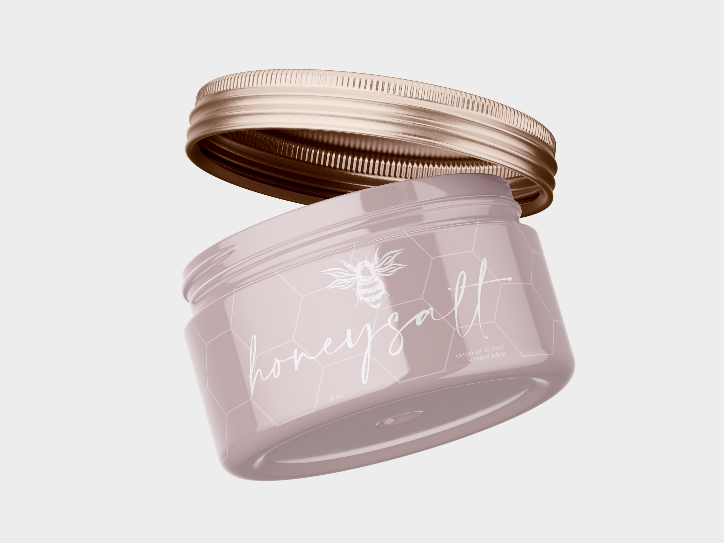 Close-up of a pink jar with a gold lid, labeled with a honeycomb pattern, a bee illustration, and white cursive text that reads "honey".