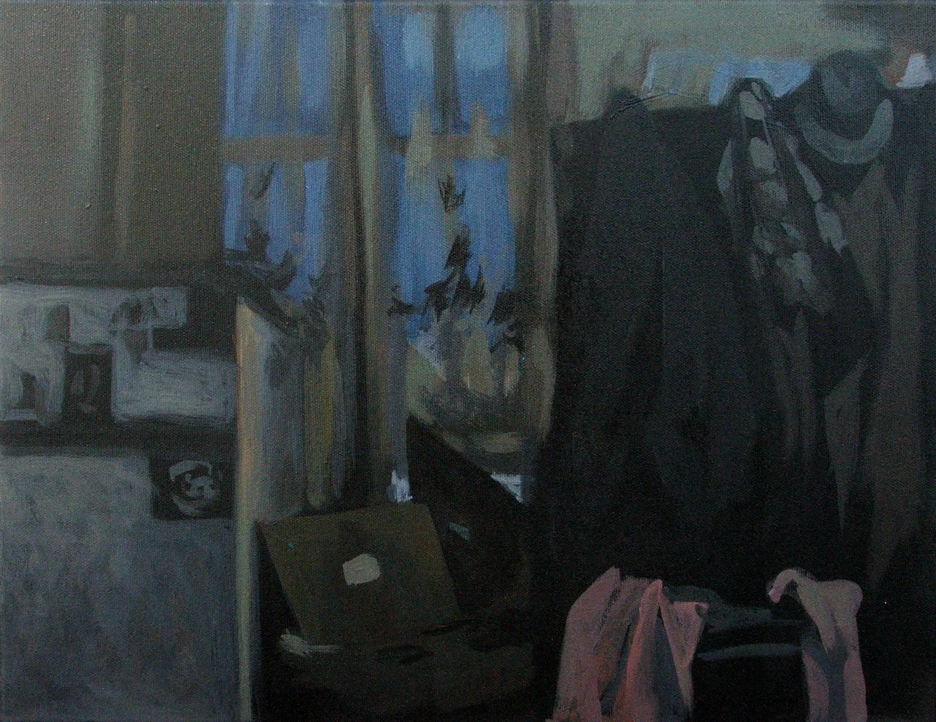 A painter's studio with a painting of cats on the wall, a closed laptop, and a pink bag on a chair.