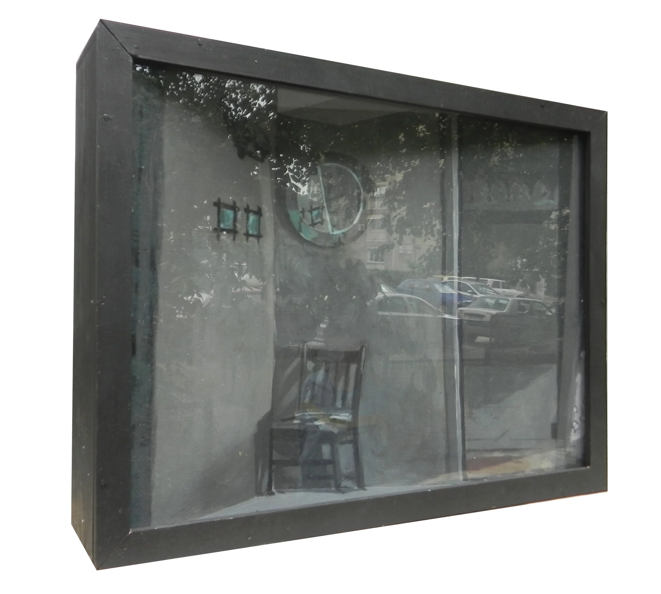 A shadowbox display case with a glass front showing a small chair inside, and a clock and some decorations mounted on the back wall.